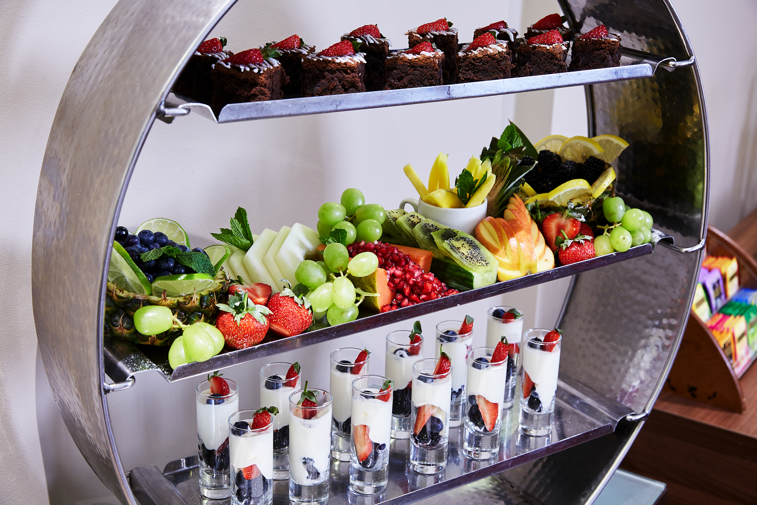 Dessert display with brownies and fruits at Charles and James Suites event.