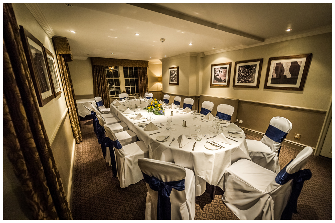 Elegant banquet setup with white linen and blue sashes at Wood Hall Hotel & Spa.