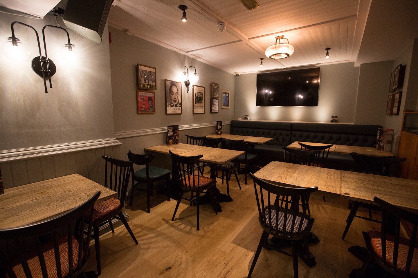 Cozy event space at O'Neill's Wardour Street with wooden tables for gatherings and meetings.
