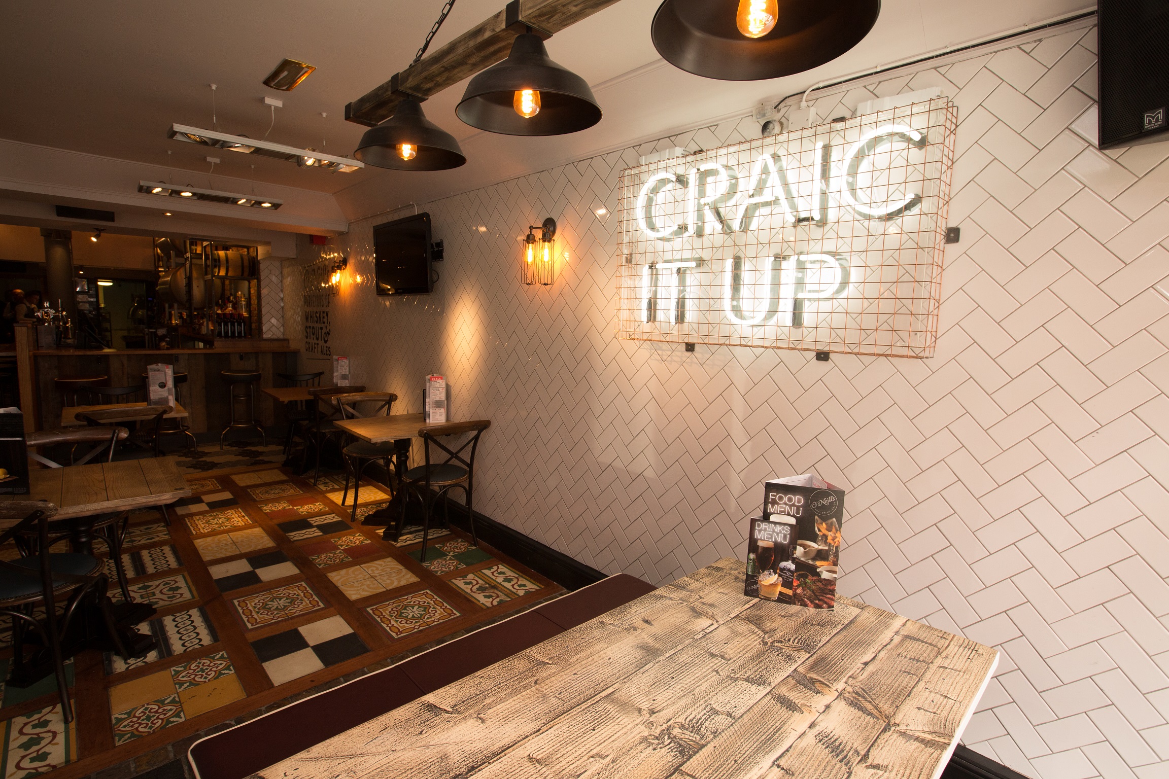 Vibrant event space at O'Neill's Wardour Street with neon sign for gatherings and networking.