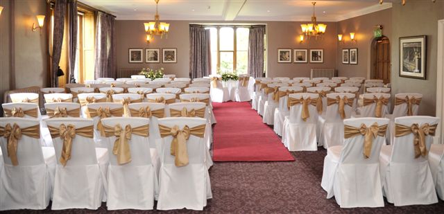 Fielden Suite at Nutfield Priory: elegant event space with white chairs and red carpet.