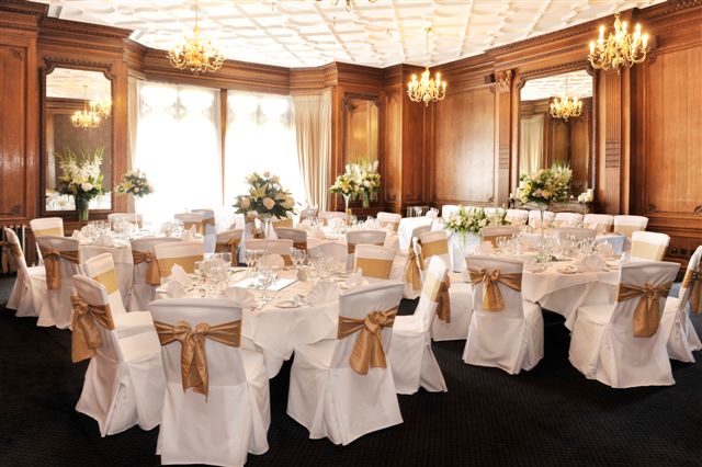 Elegant Gibson Room at Nutfield Priory for formal events with white tables and gold accents.