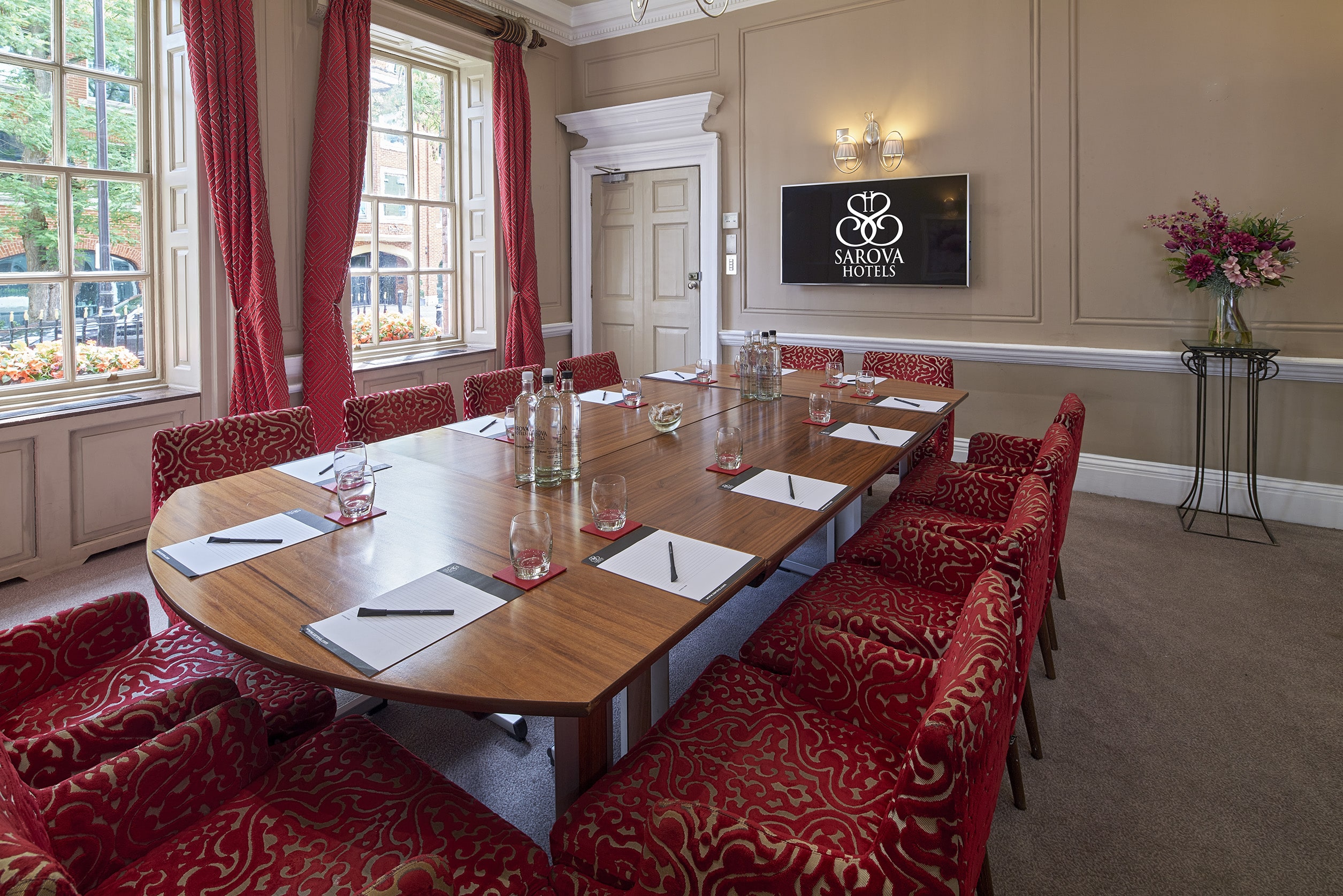 Sienna Room meeting space with elegant wooden table and plush chairs for professional gatherings.