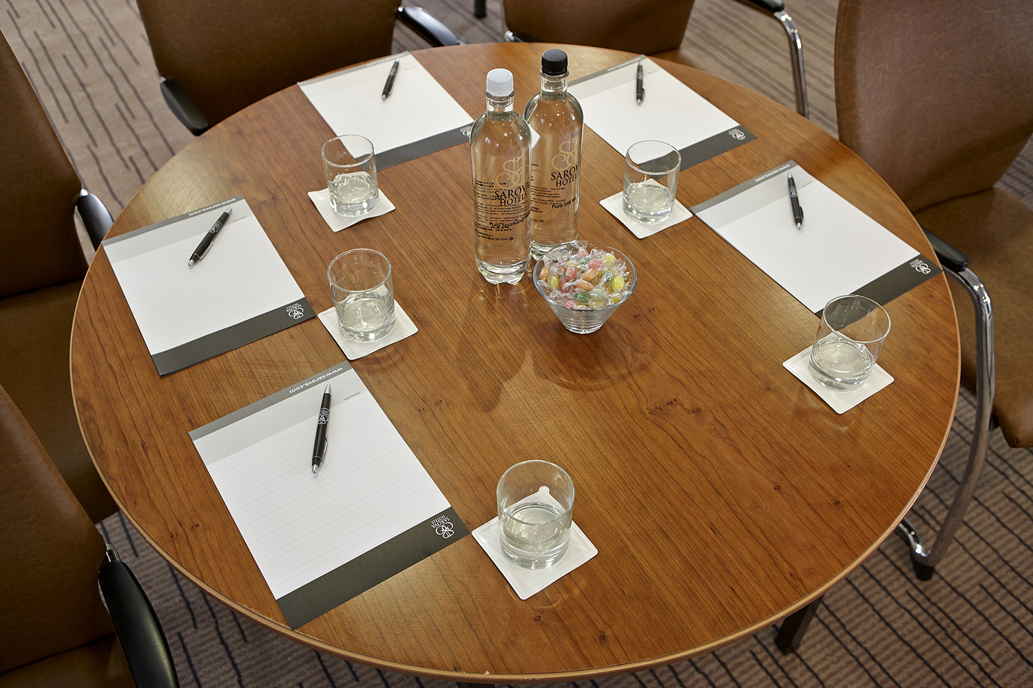 Buckingham Suite meeting setup with round table, notepads, and water bottles.