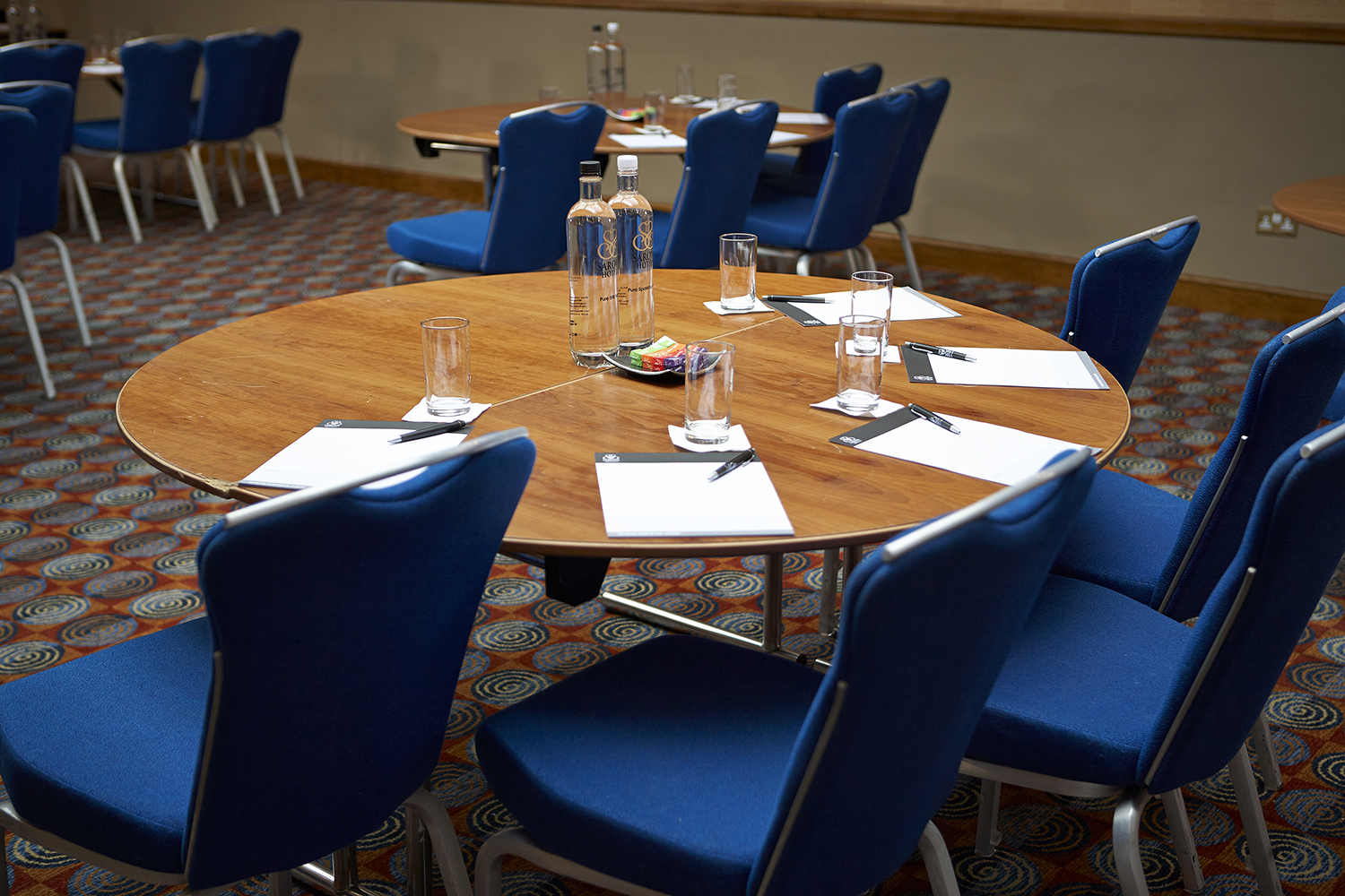 Shaw Suite meeting setup with round tables, blue chairs for corporate events.