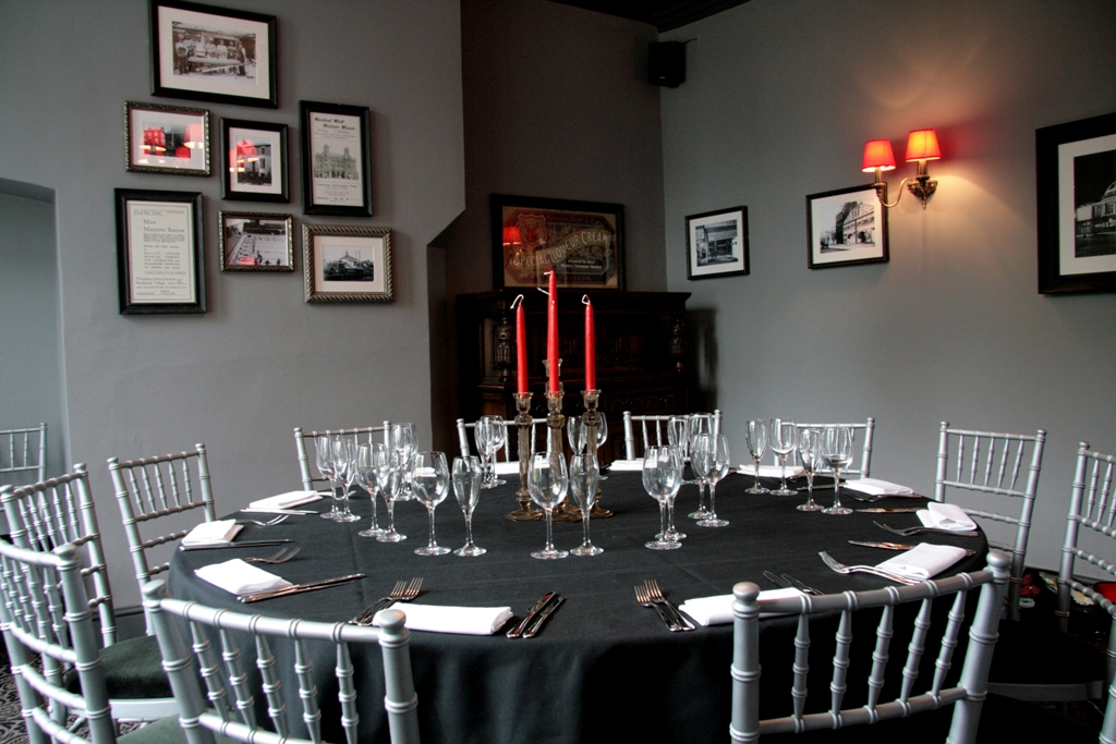 Elegant round table with red candles in The Honor Oak's private dining room for upscale events.
