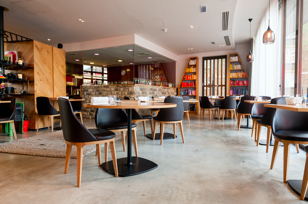 Modern restaurant interior with wooden tables, ideal for networking events and meetings.