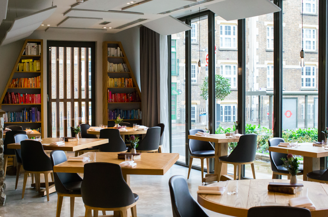 Modern restaurant with round tables, ideal for networking events and intimate gatherings.