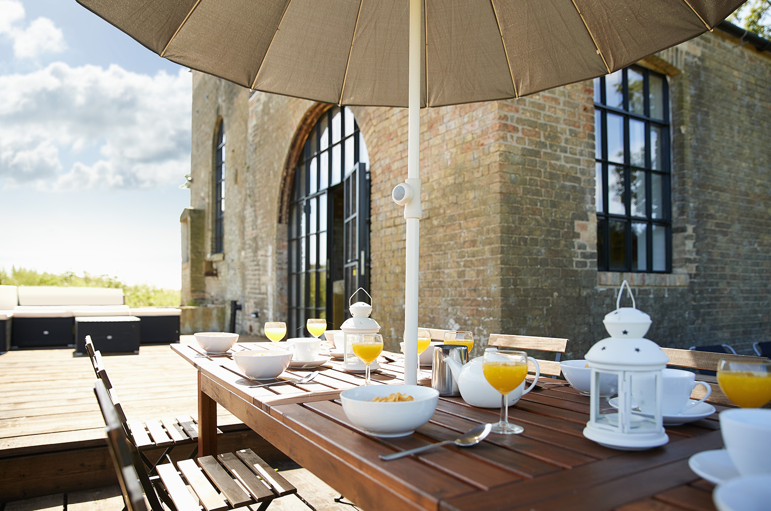 Outdoor breakfast meeting at The Pumphouse with elegant table under an umbrella.