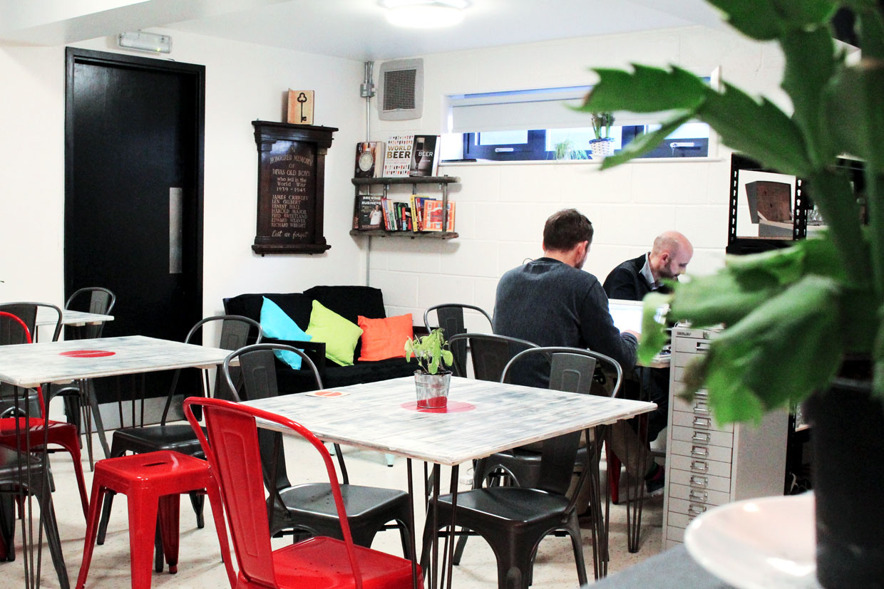 Cozy hot desk meeting space with vibrant cushions for brainstorming and networking events.