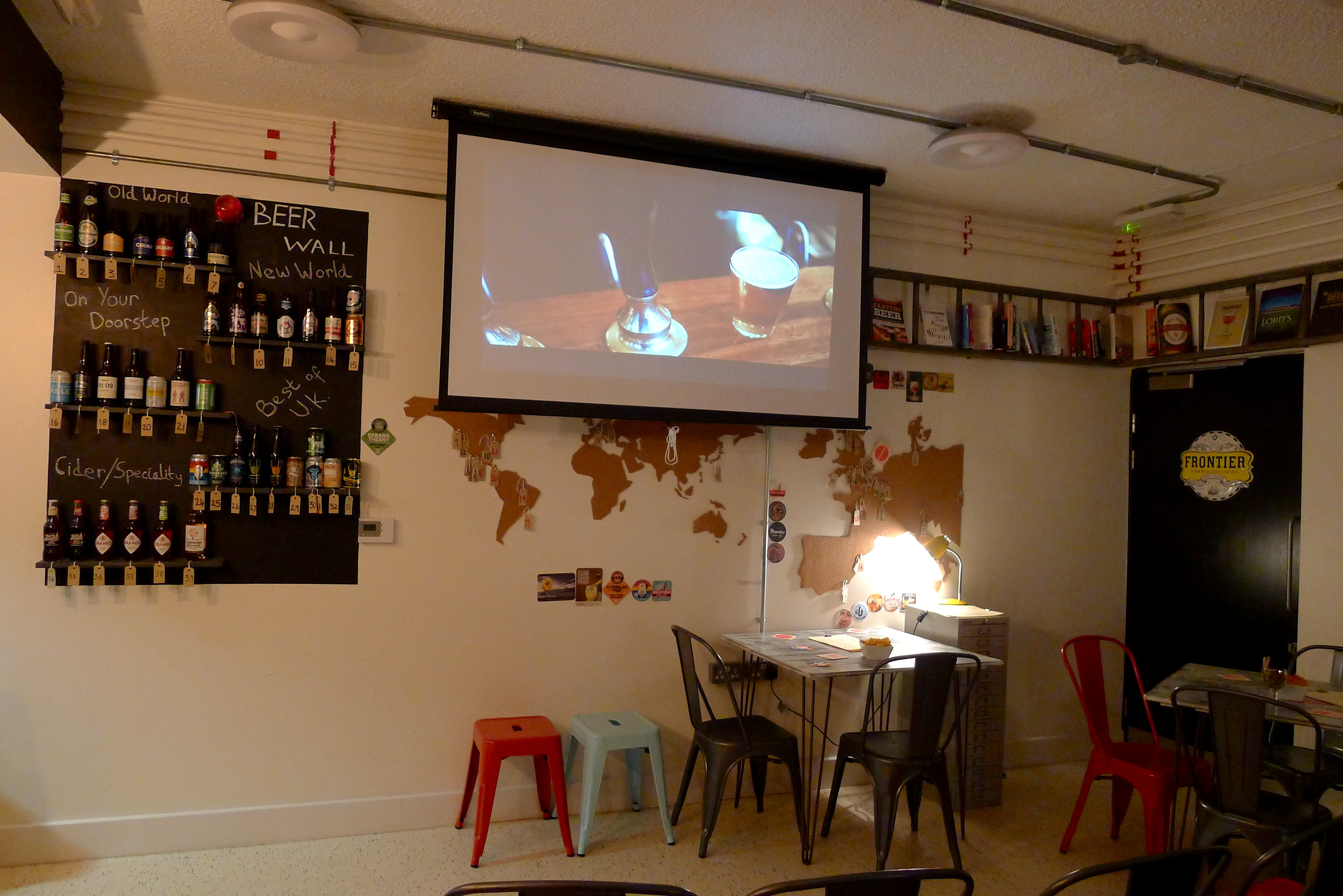 Versatile event space with beer wall and projection screen for mixers and presentations.