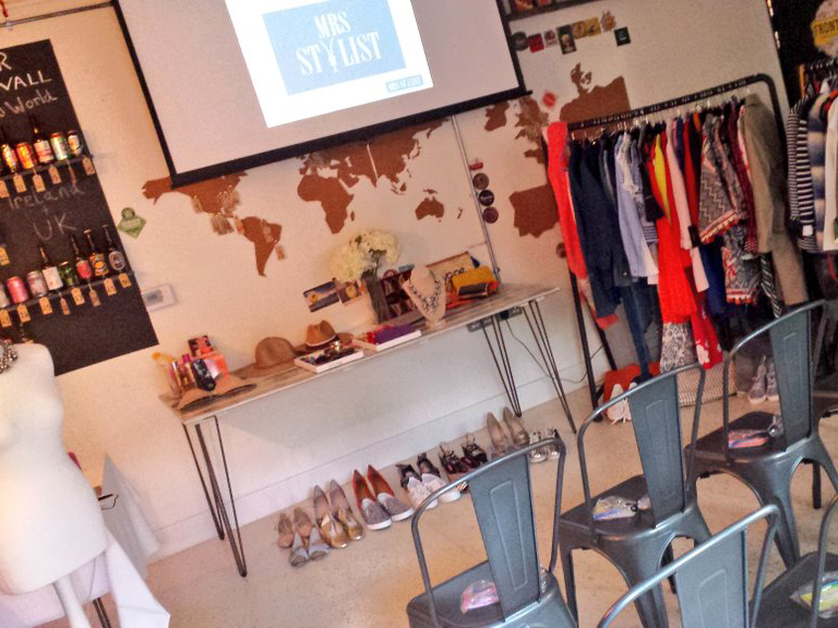 Stylish workshop space with world map backdrop and curated fashion display.
