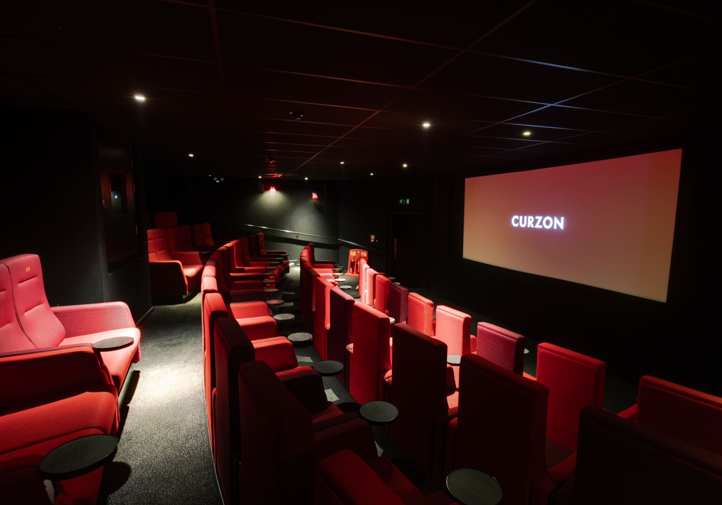 Modern cinema space with plush red seating for intimate screenings and private events.