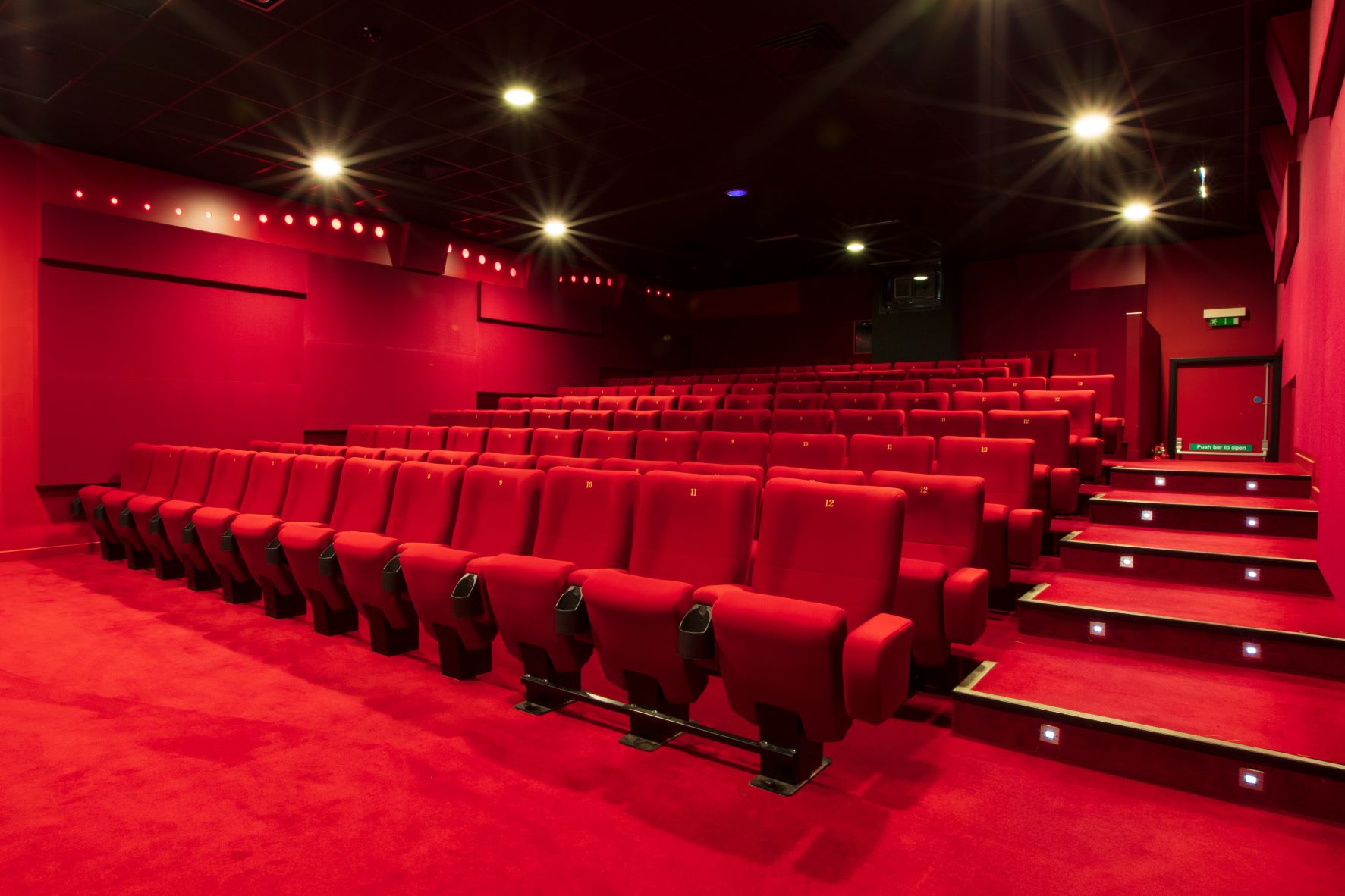 Modern theater with plush red seating, ideal for film screenings and corporate events.