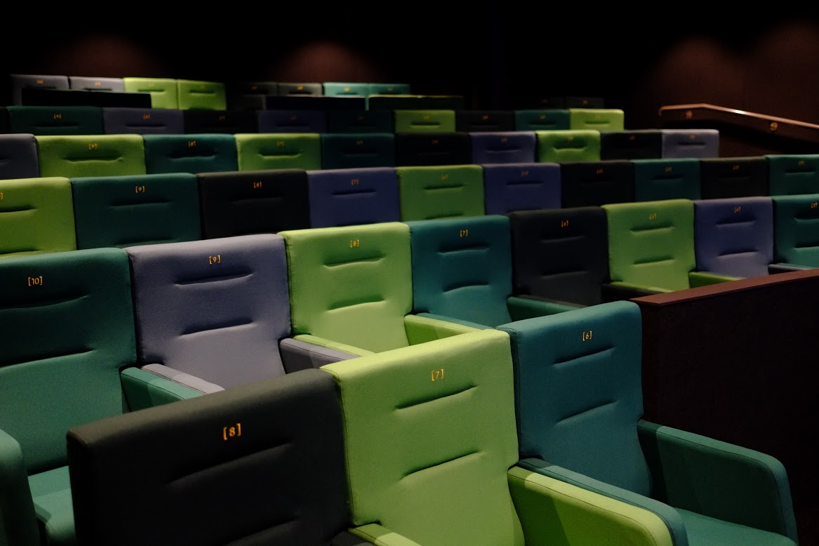 Modern auditorium in Curzon Sheffield with vibrant green and blue seating for screenings.