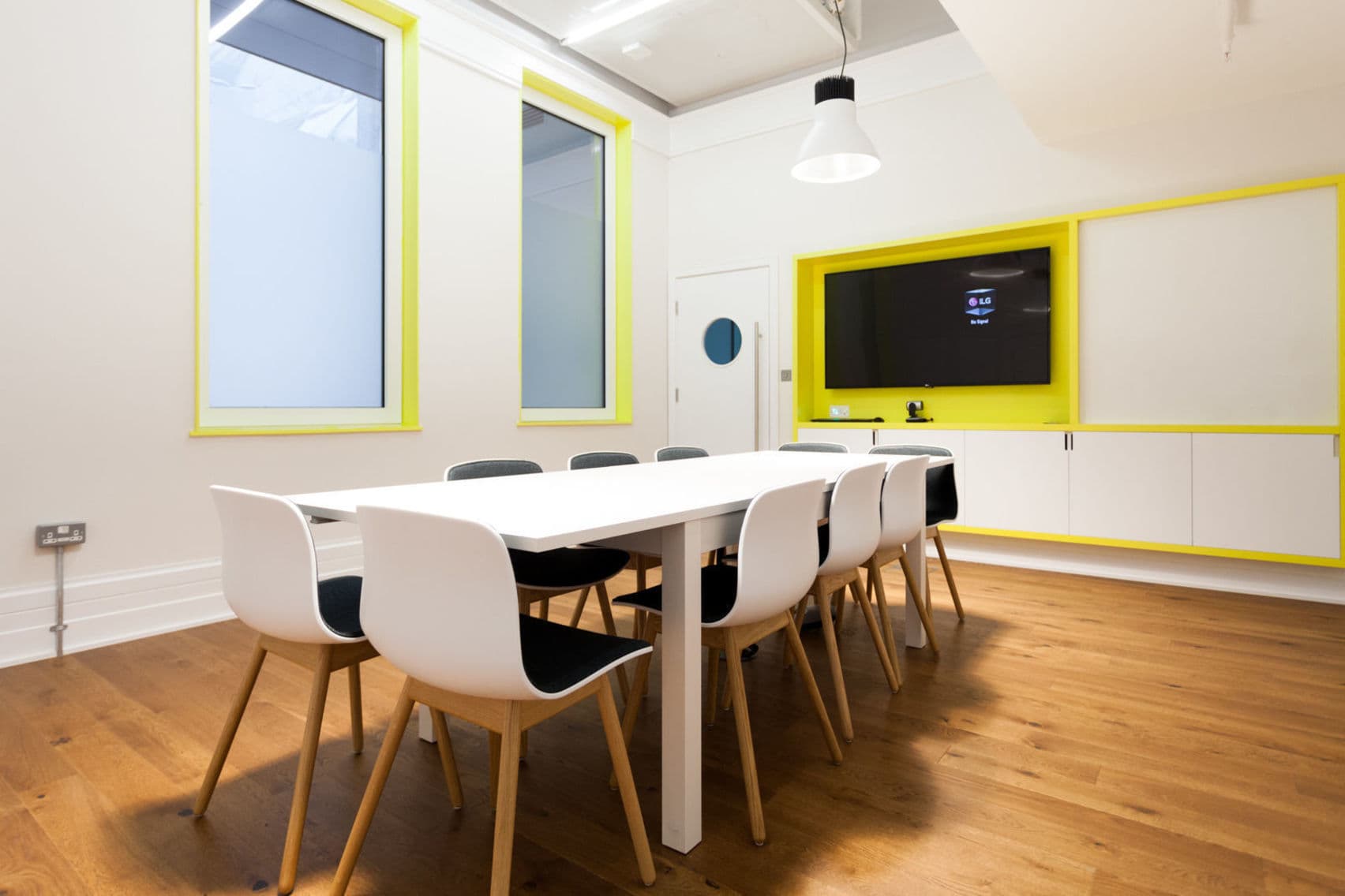 Modern Menlo Meeting Room with white table, yellow accents for collaborative events.