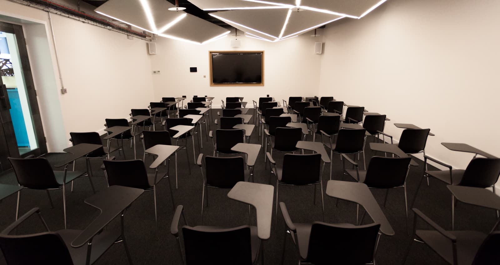 Modern meeting room with black chairs, ideal for presentations and workshops.