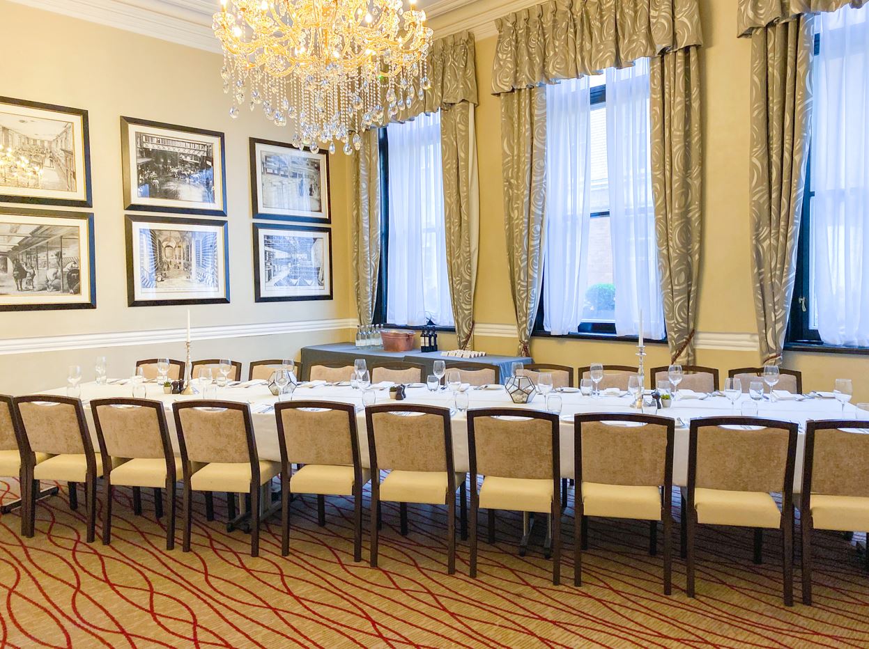 Elegant Melville Room with chandelier, ideal for formal dinners and meetings.