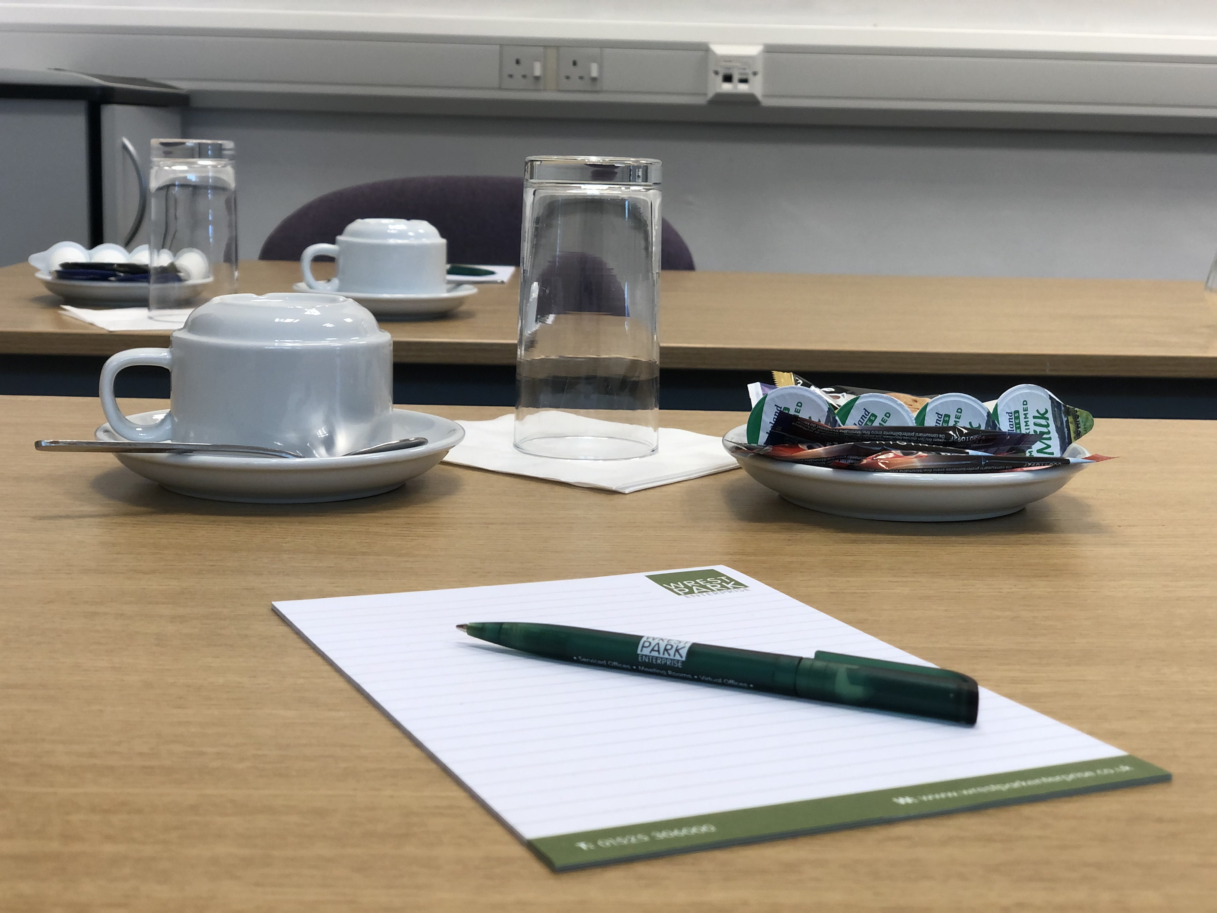 Boardroom setup in Capability House with snacks, cups, and notepads for meetings.