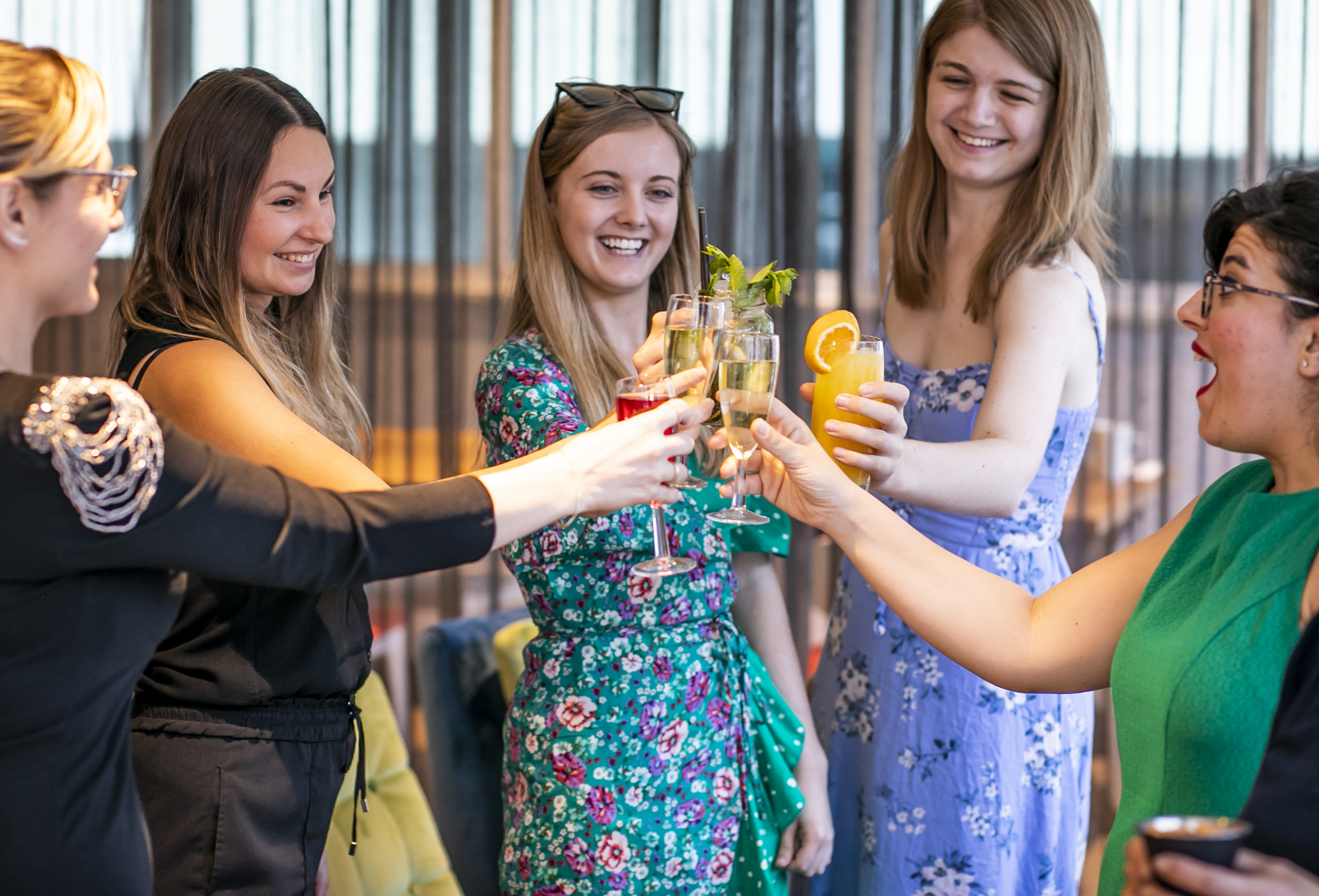 Women toasting drinks at The Glasshouse, Camden Lock, celebrating networking and events.
