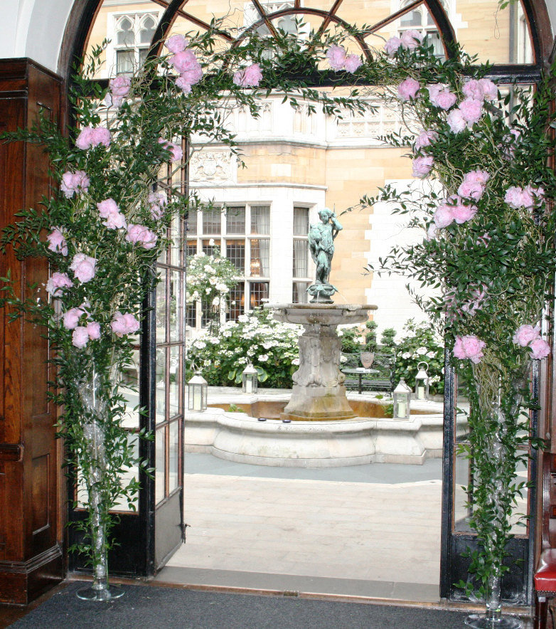 Elegant outdoor space at The Cloisters, featuring a fountain and pink flowers for weddings.