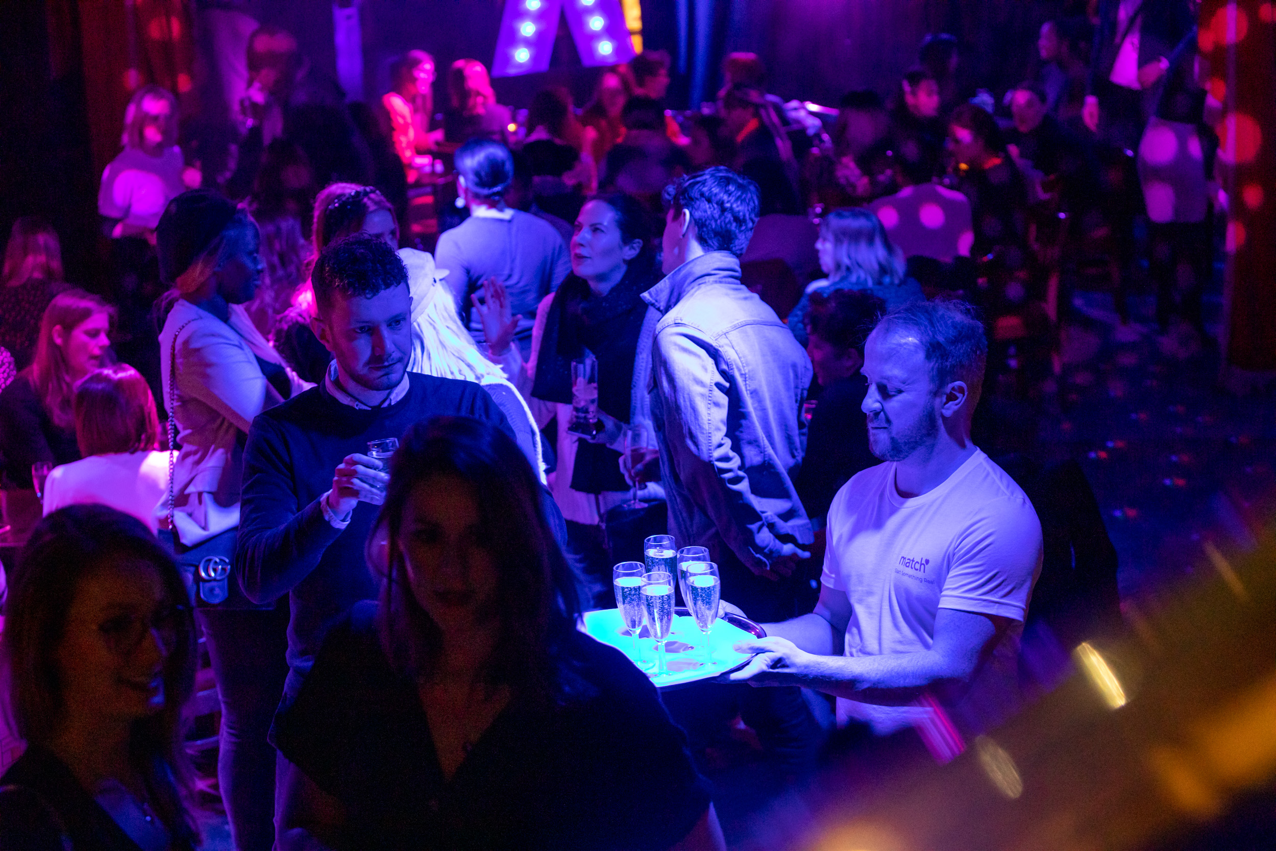 Vibrant networking event at Phoenix Arts Club with colorful lighting and engaged guests.