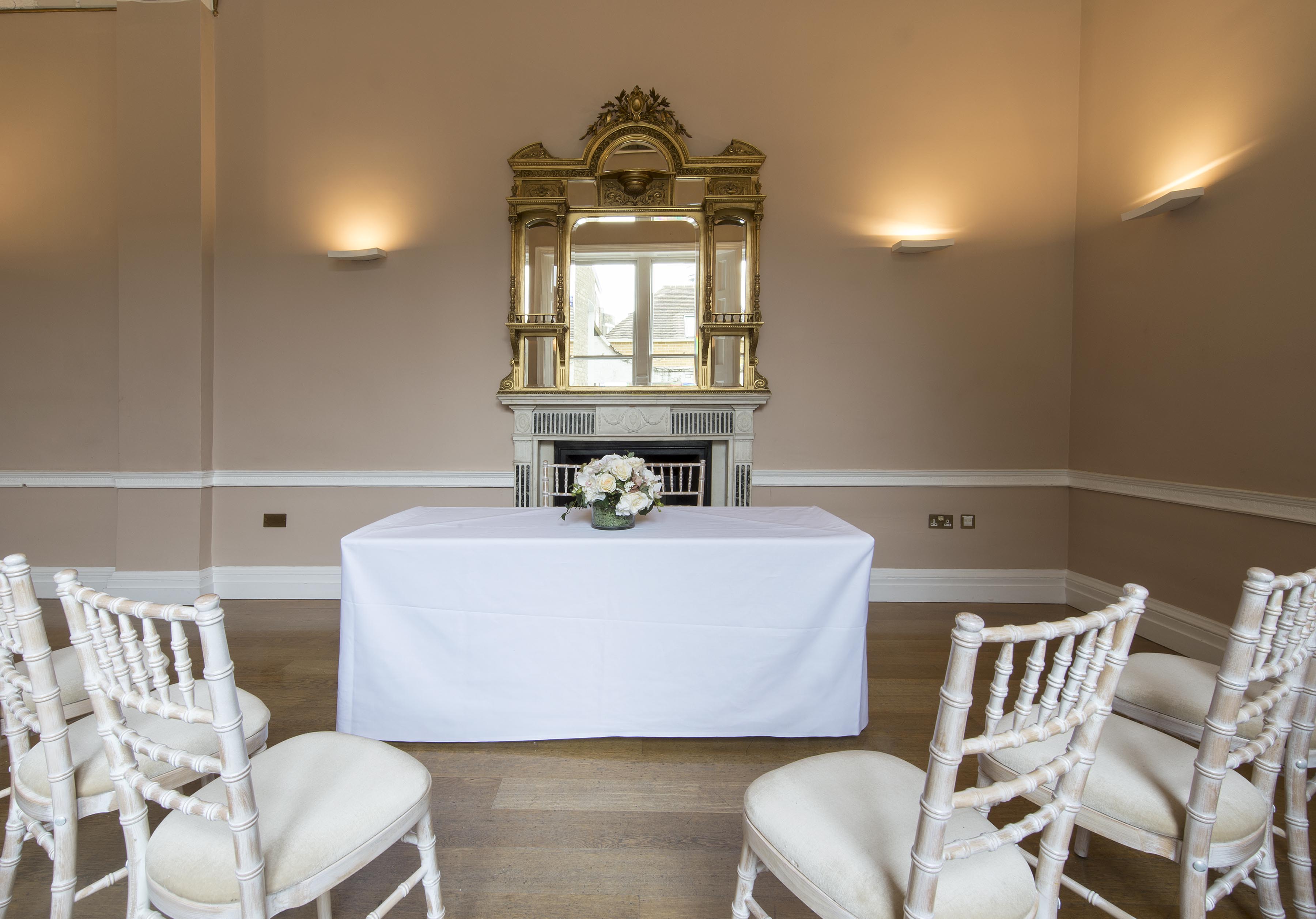 Elegant meeting room with white table and floral centerpiece, perfect for corporate workshops.