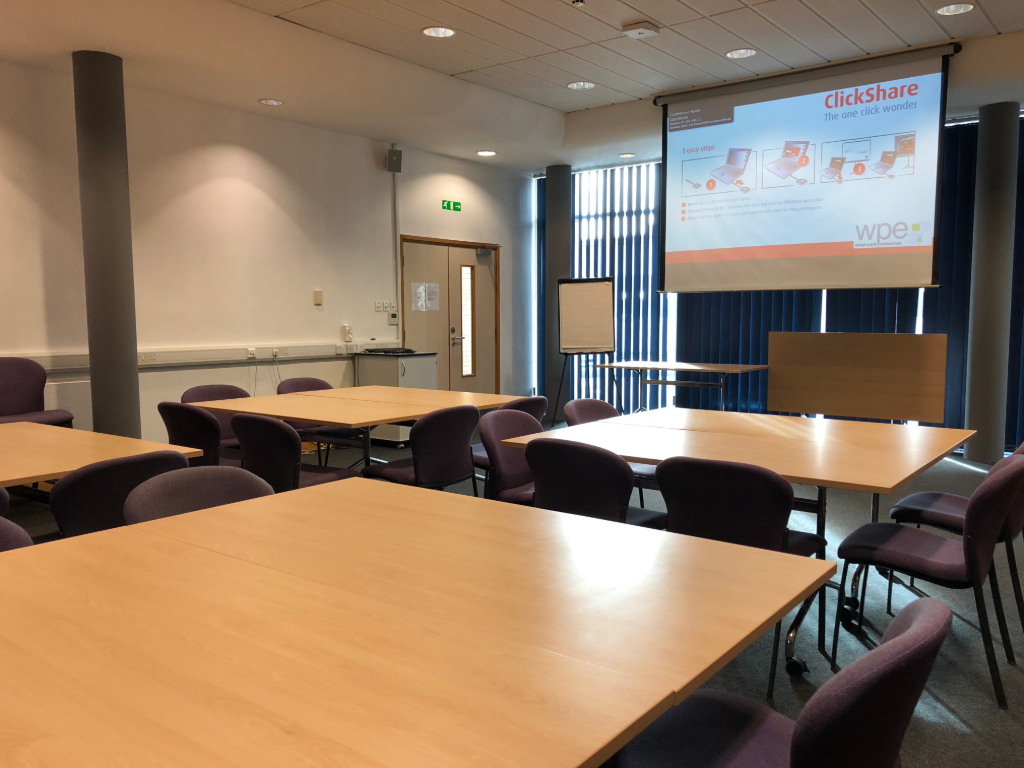 Conference Room in Capability House with projector screen for collaborative meetings.