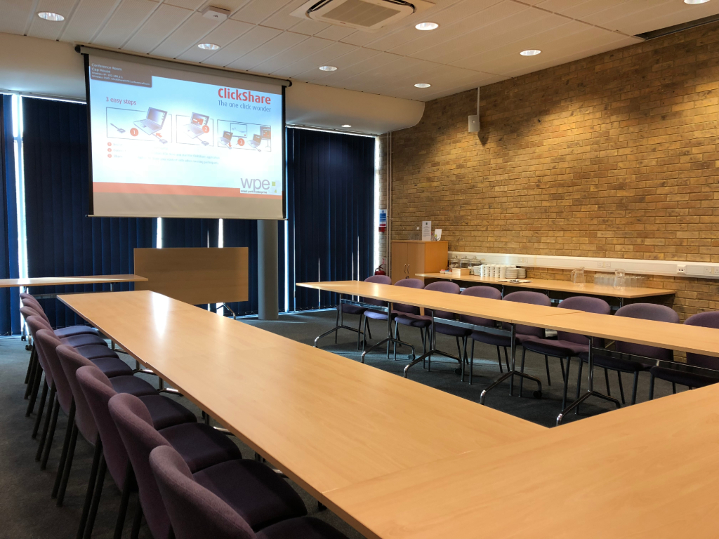 Conference Room in Capability House with U-shaped tables for collaborative meetings.