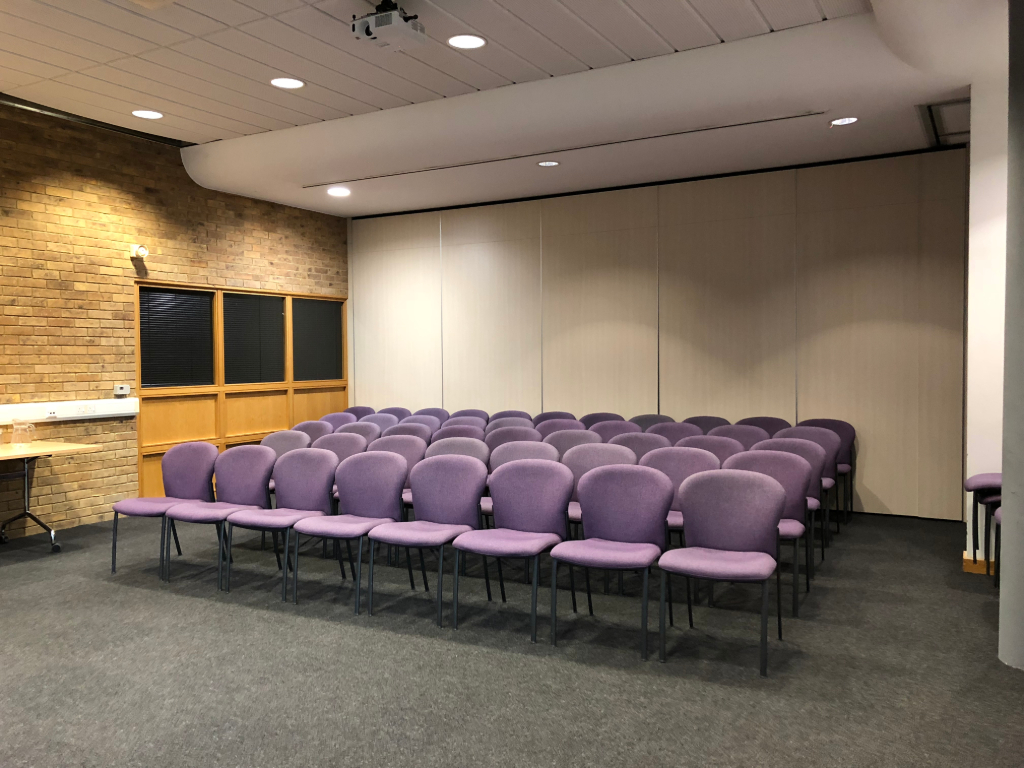 Conference Room in Capability House with purple chairs, ideal for workshops and presentations.