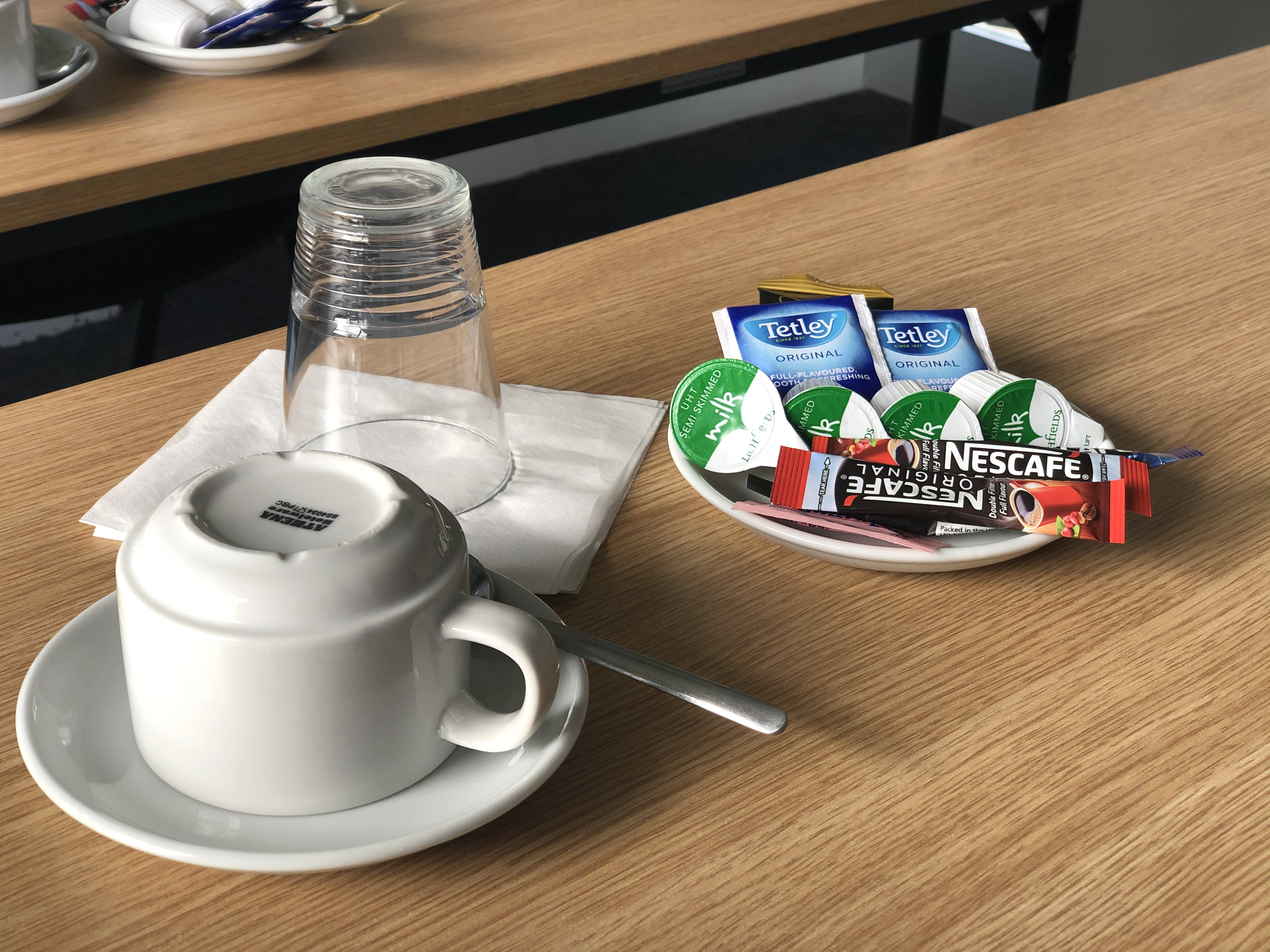 Coffee setup in Enterprise House Room 019 for meeting breaks, featuring creamers and sweeteners.