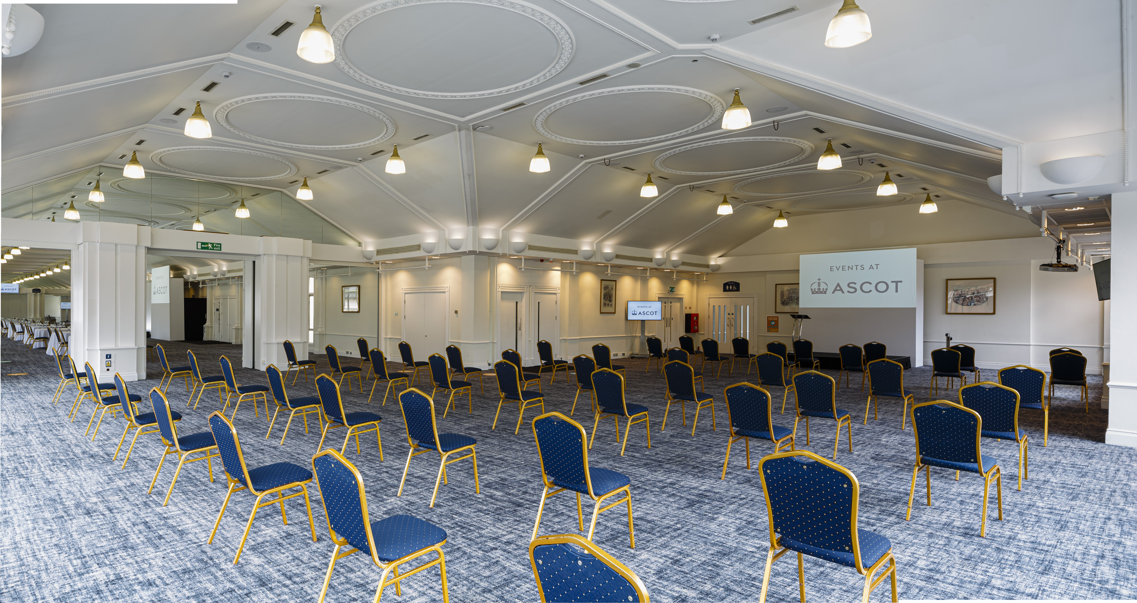Pavilion Suite at Ascot Racecourse, spacious meeting room with blue chairs, ideal for events.