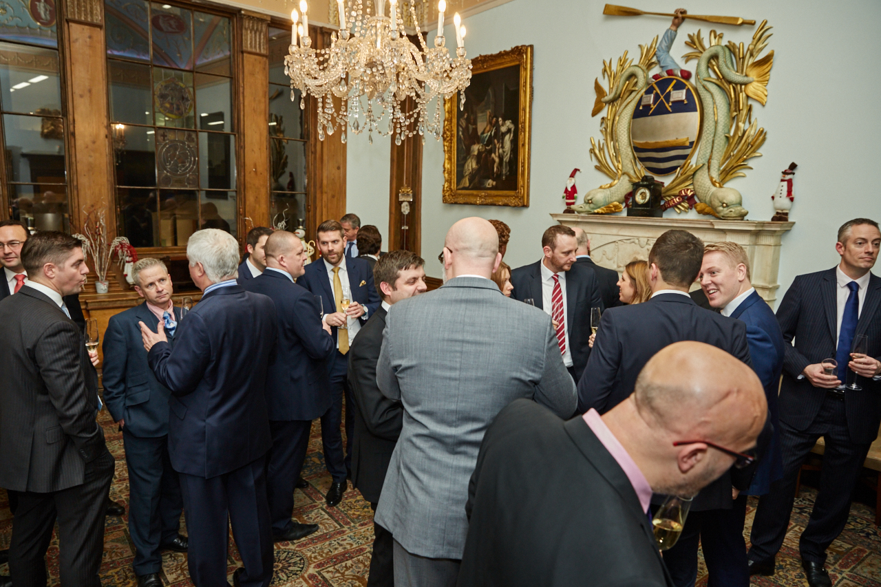 Elegant courtroom networking event with professionals in business attire at Watermen's Hall.