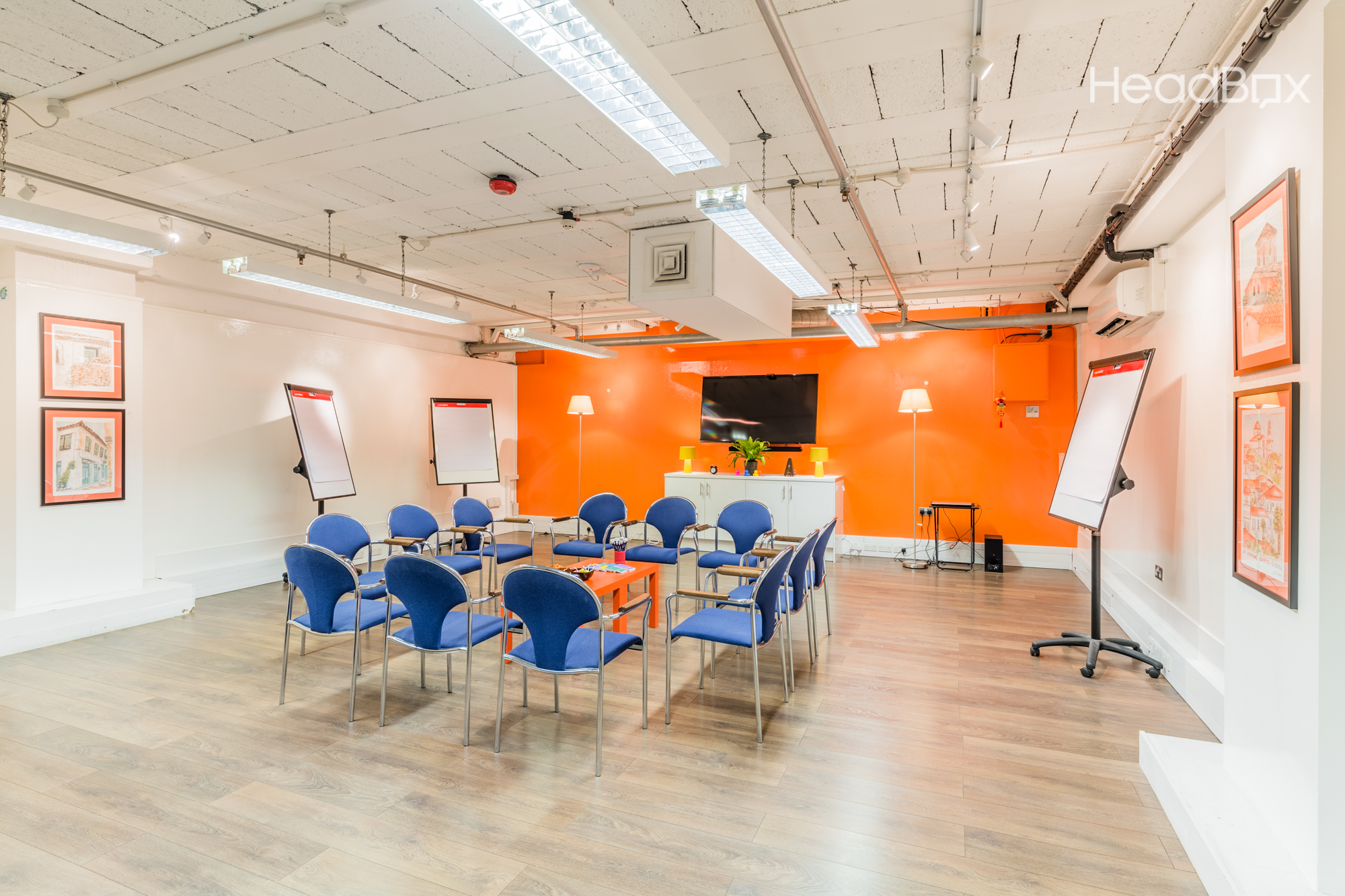The Bright Room with orange wall, ideal for workshops and team meetings.