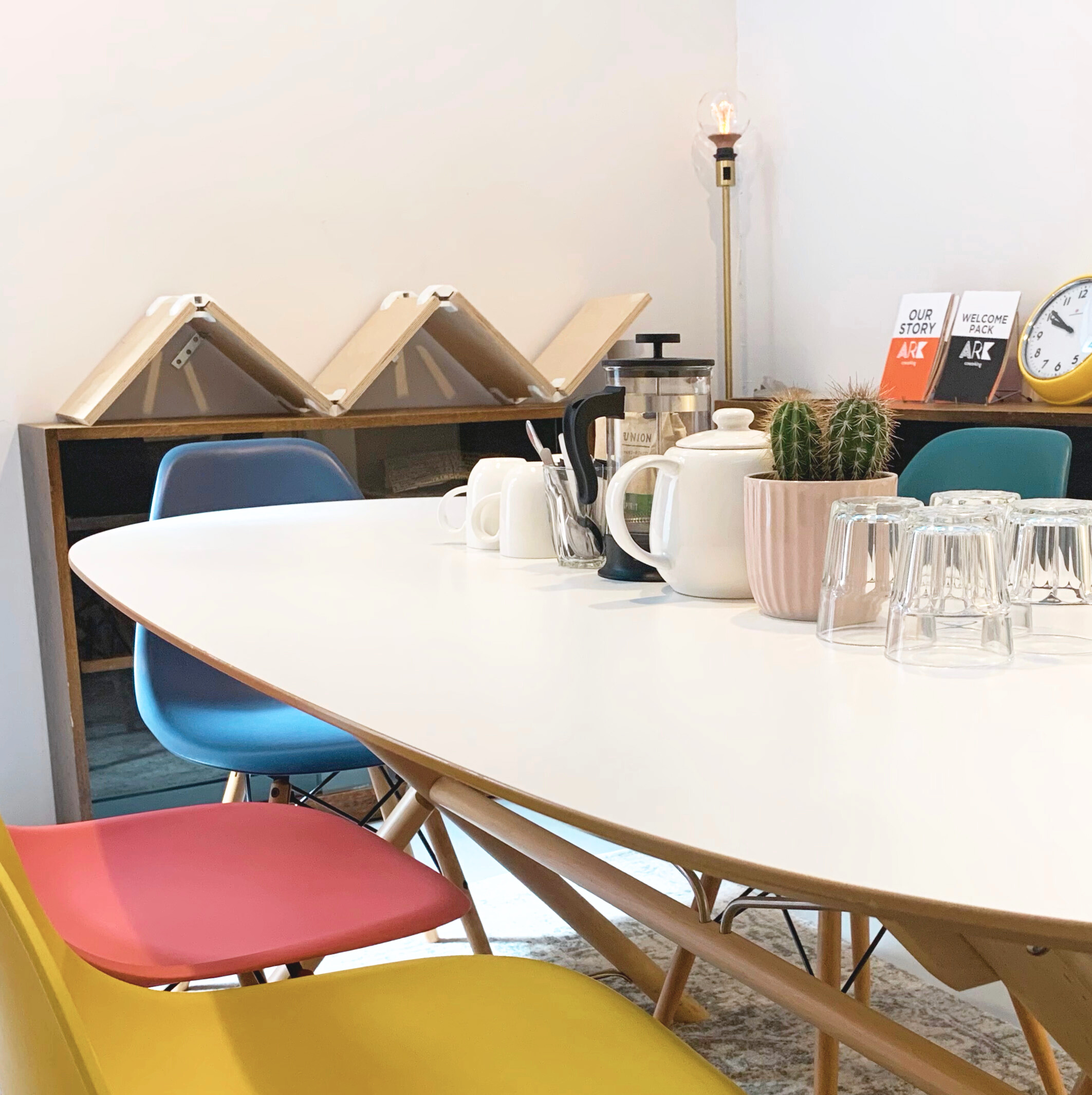 Modern ARK coworking meeting room with oval table, colorful chairs for collaboration.