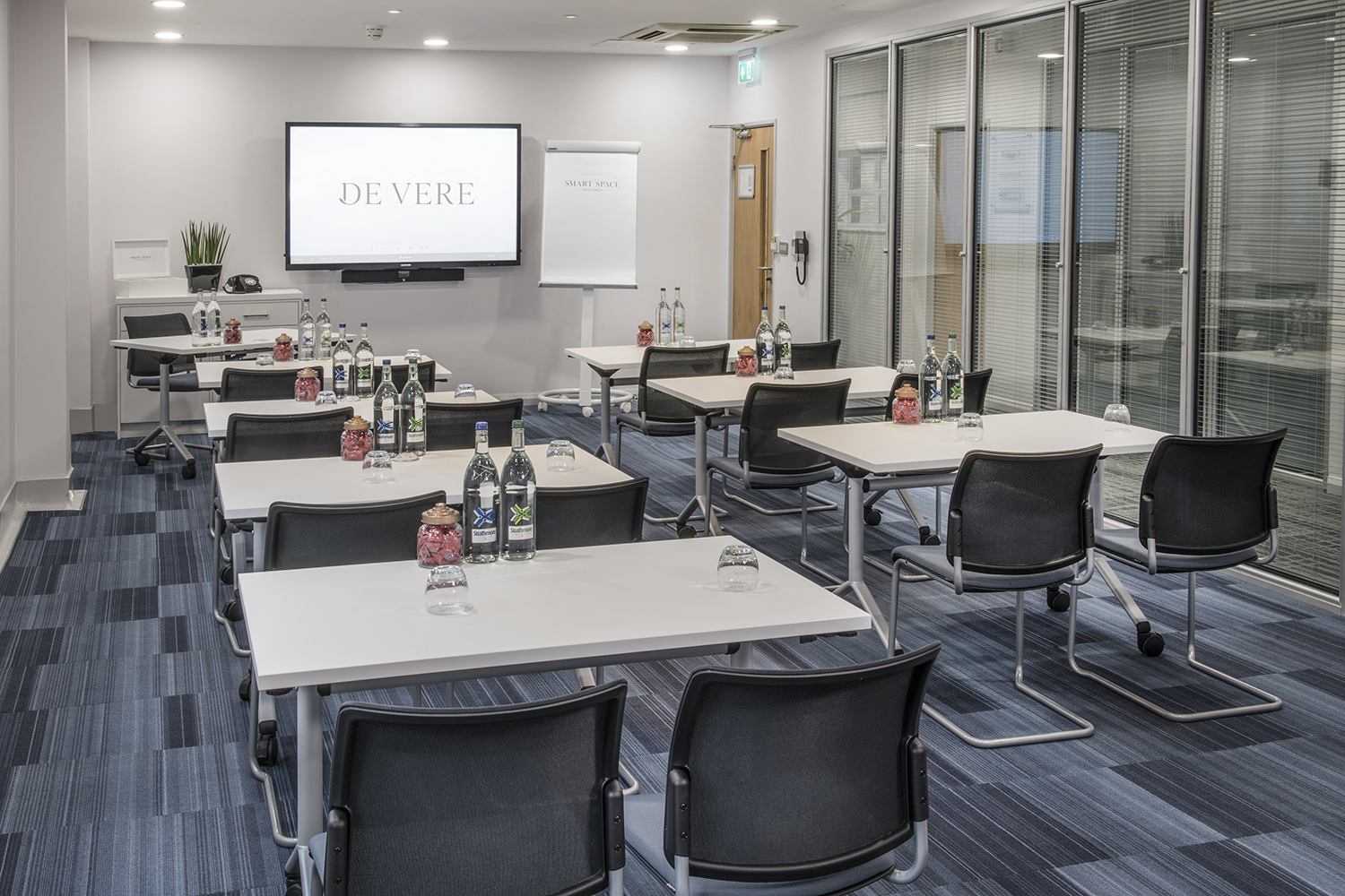 Trafalgar Suites meeting room with classroom setup for professional events and presentations.