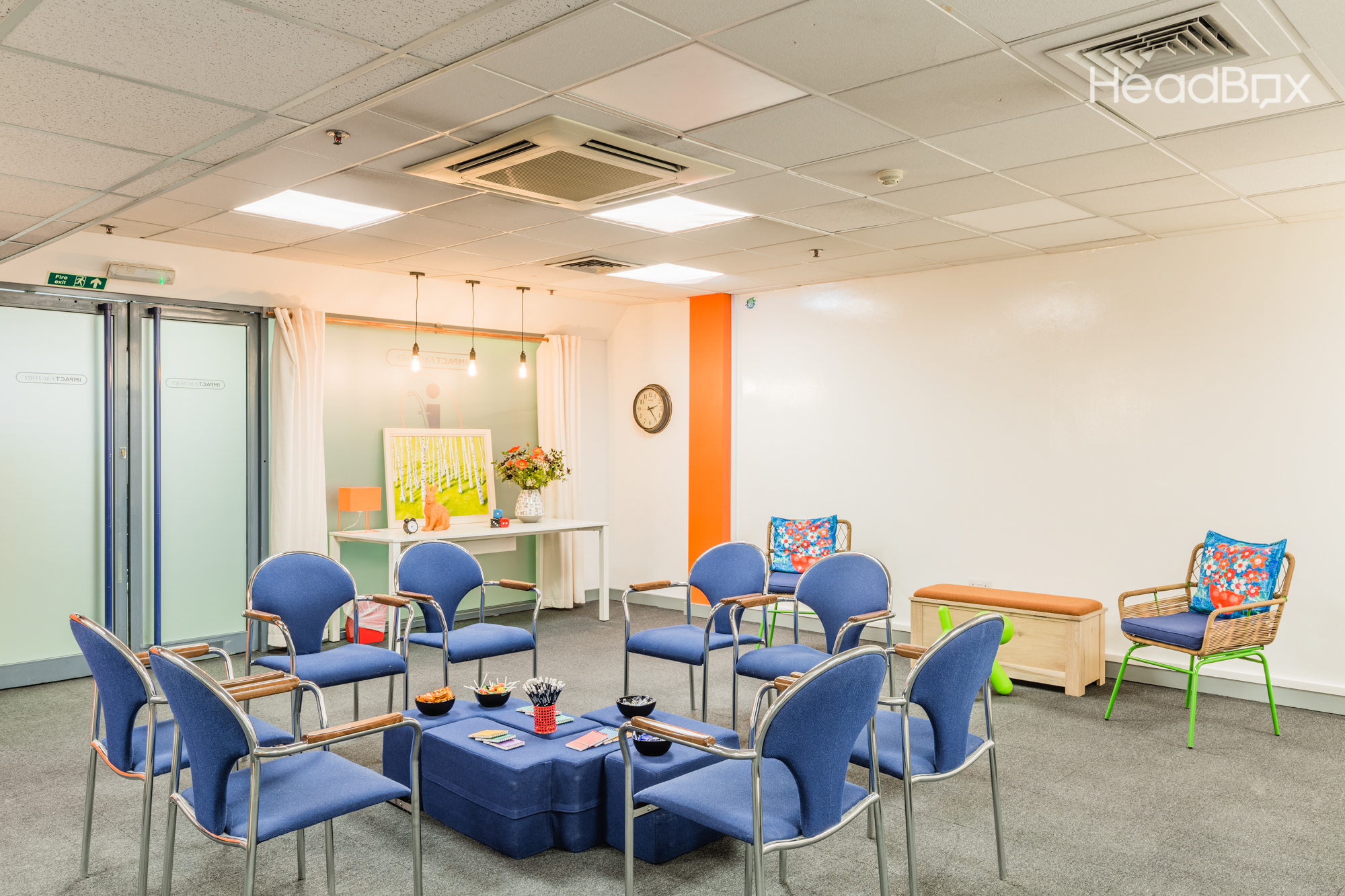 Bright White Room at Impact Factory, featuring circular seating for collaborative workshops.