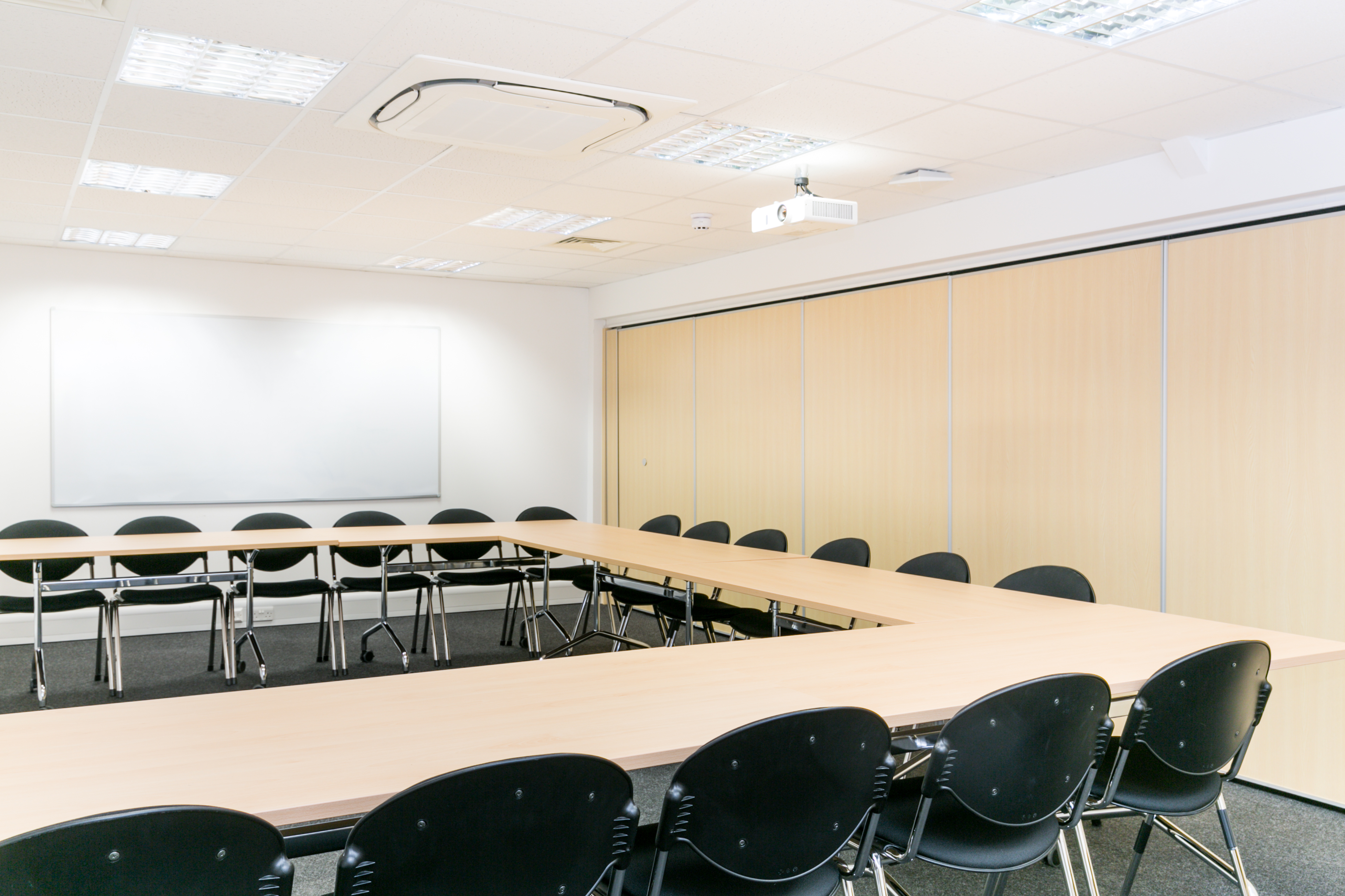 Versatile meeting room with U-shaped table, ideal for workshops and strategy sessions.