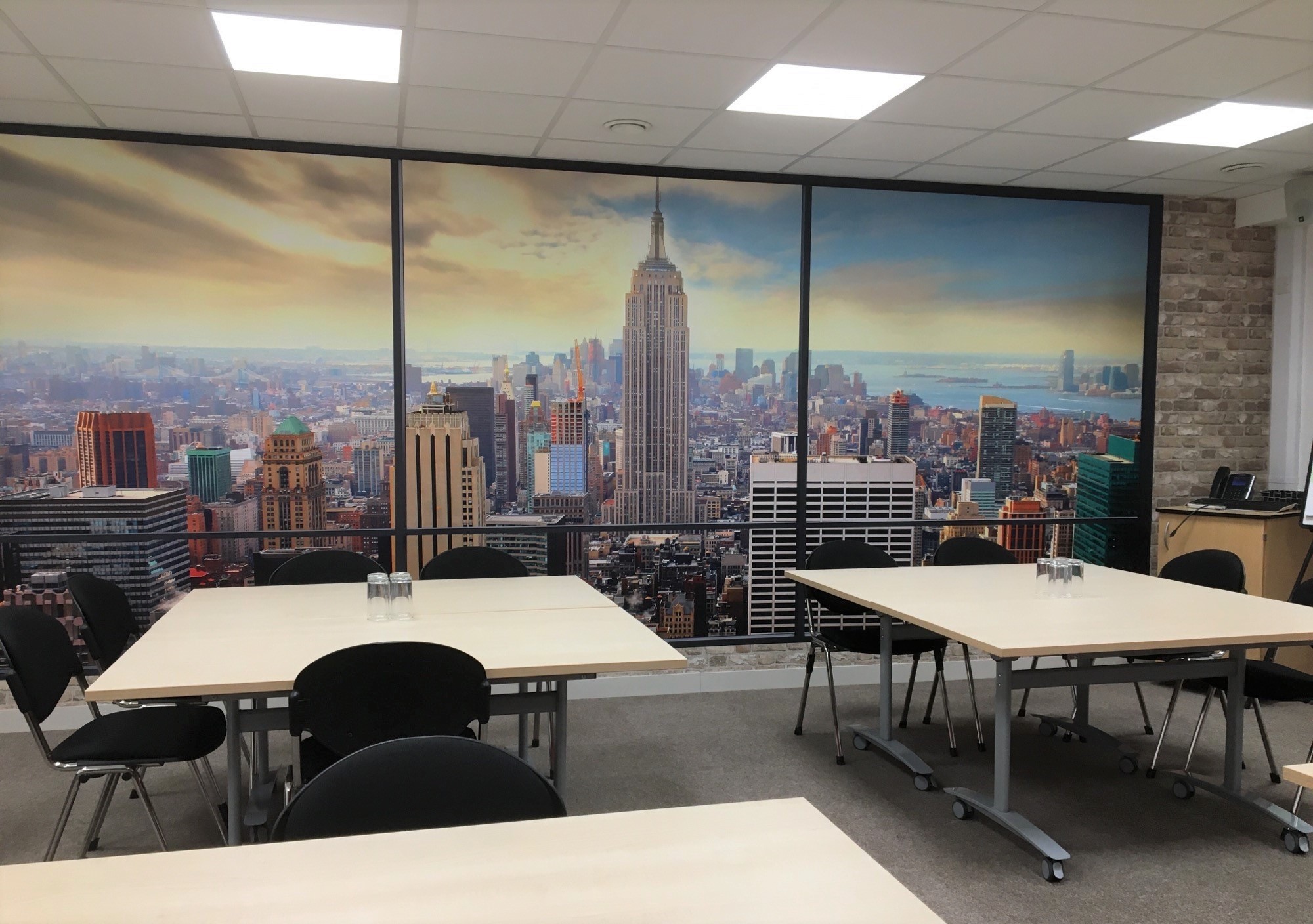Modern conference room with NYC skyline view, ideal for meetings and workshops.