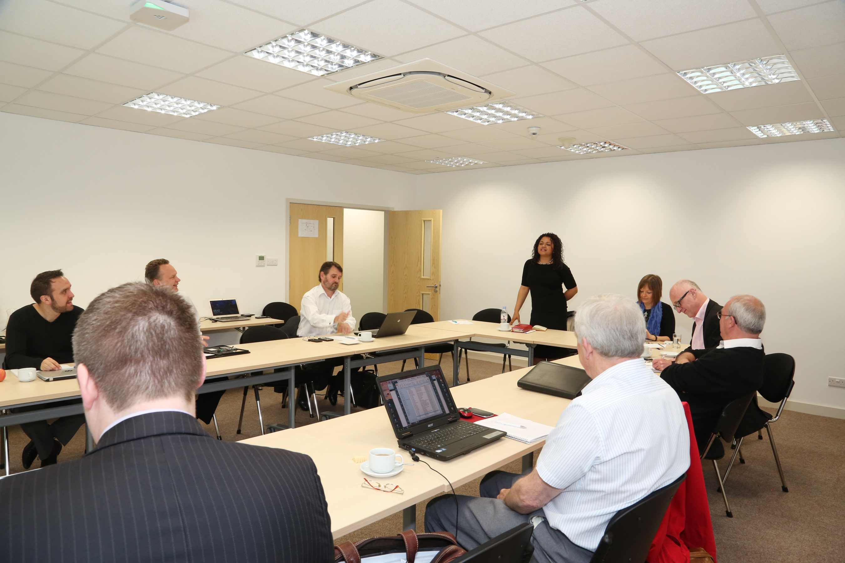 Board Room in Bowman House: professional meeting with engaged participants and laptops.
