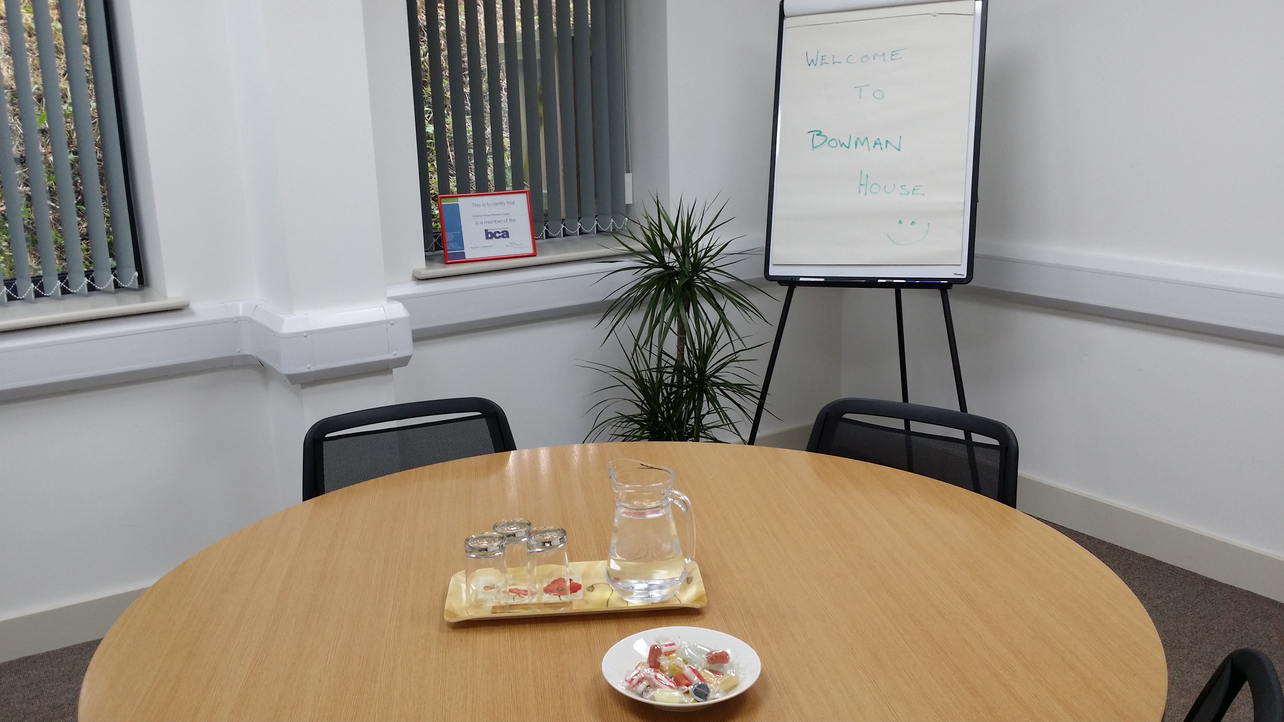 Meeting room in Bowman House with round table, snacks, ideal for collaborative events.