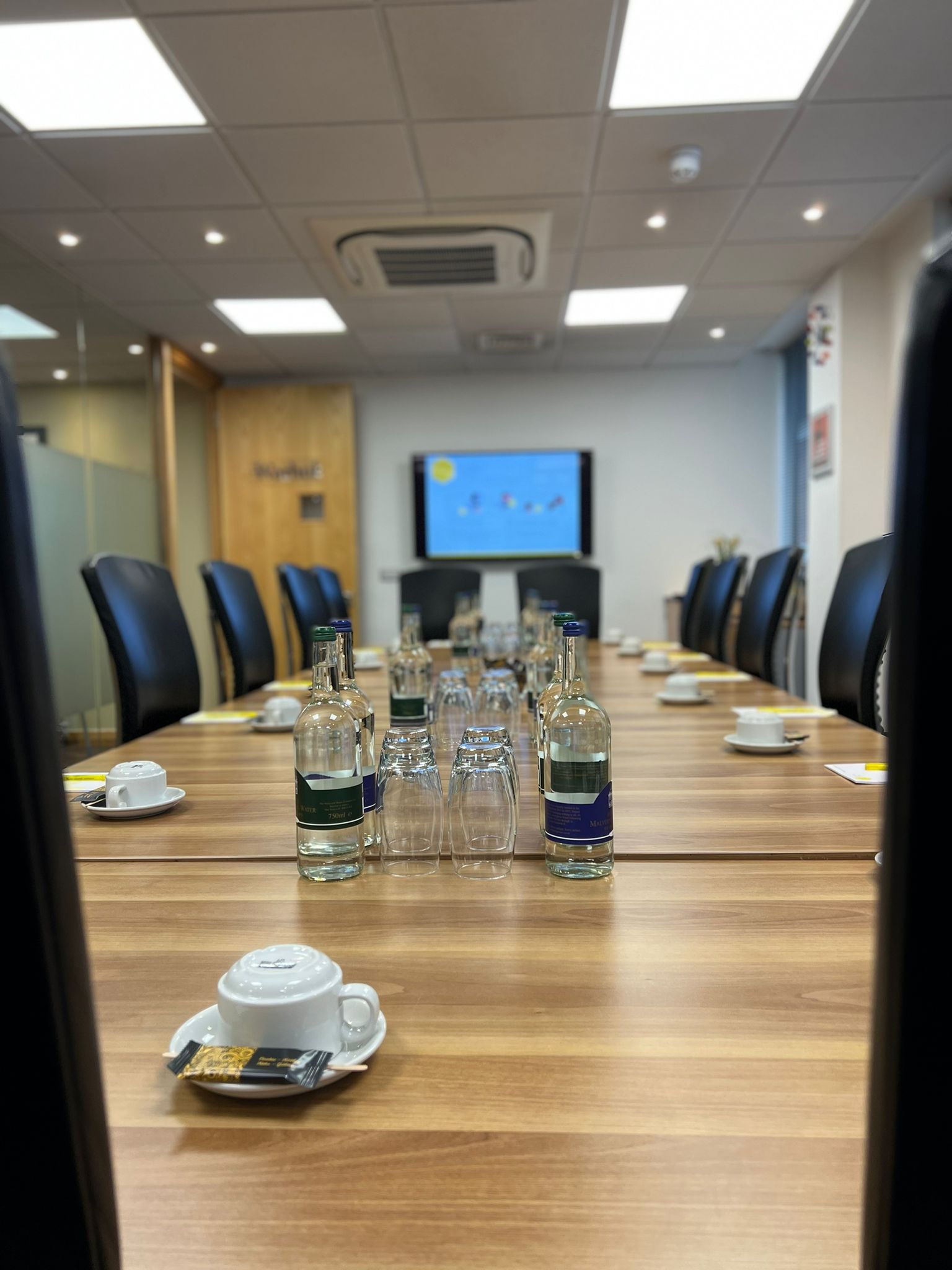 Dali Suite meeting room with wooden table, ready for professional discussions and presentations.