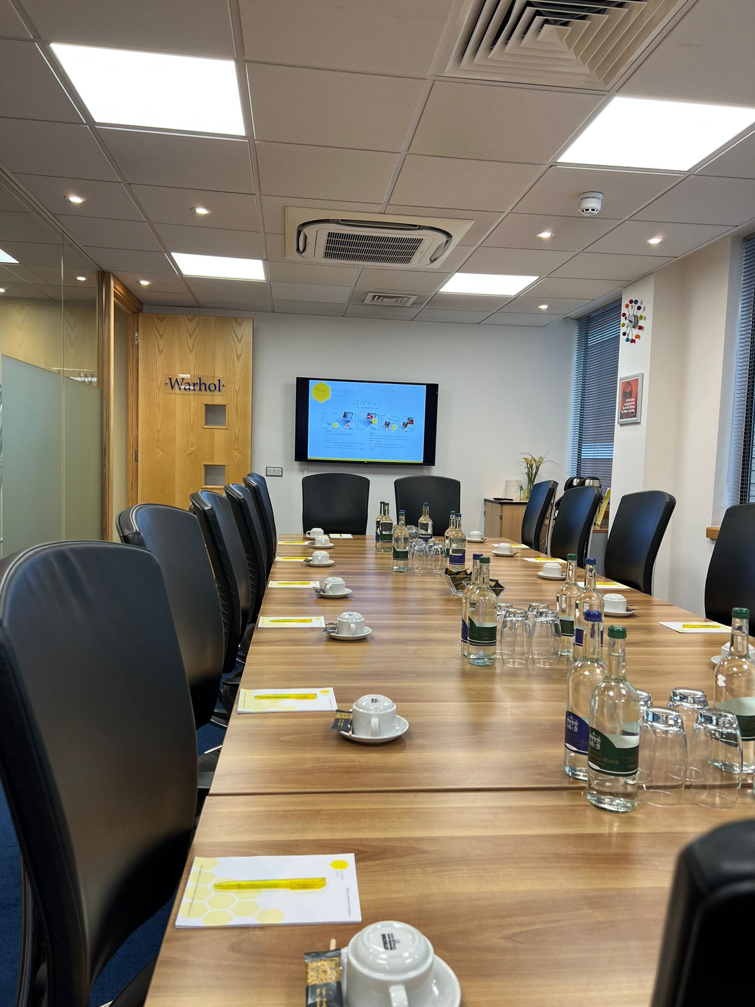Dali Suite meeting room with wooden table, ideal for corporate events and presentations.