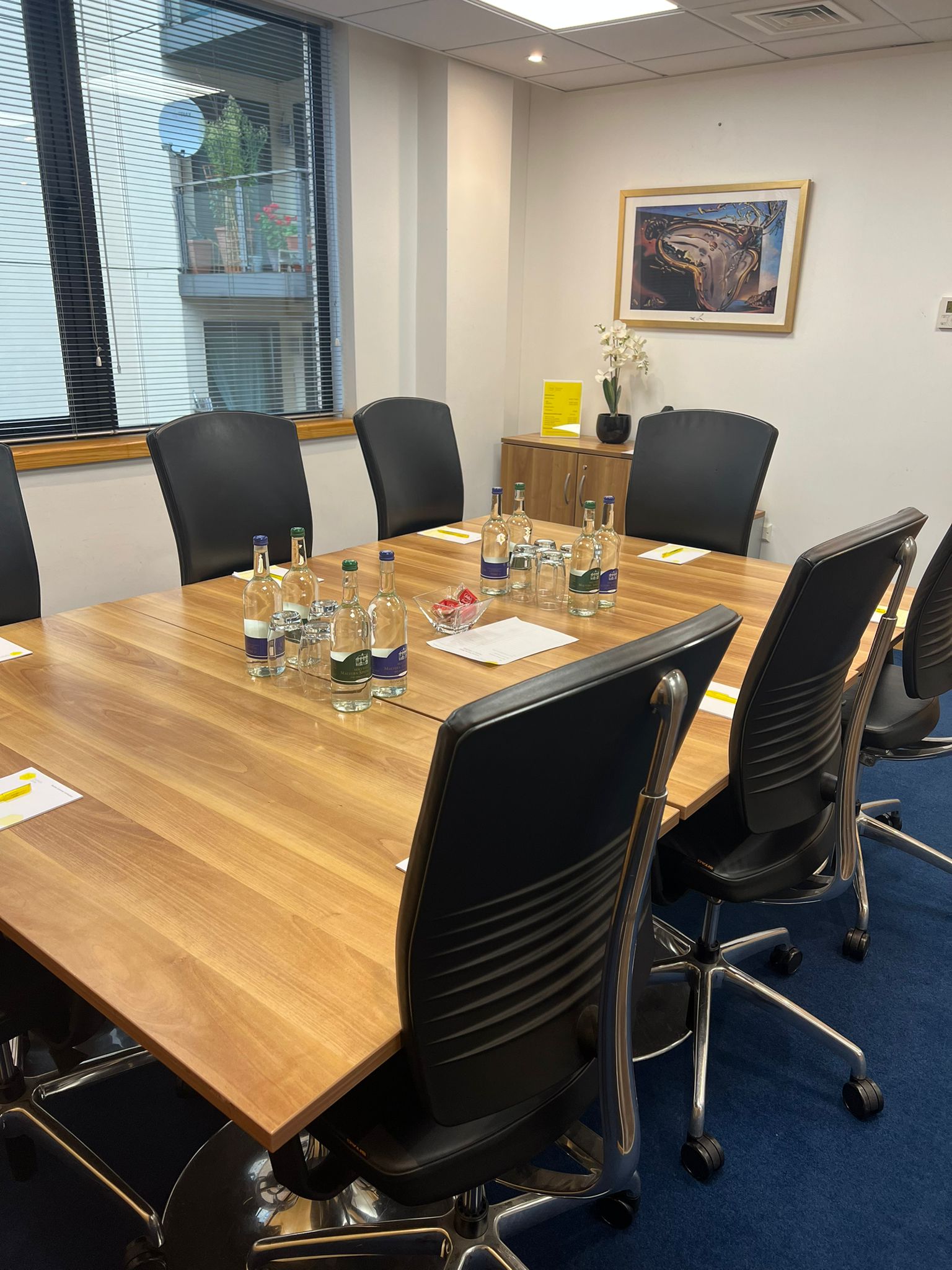 Dali meeting room with polished table, black chairs for professional gatherings.
