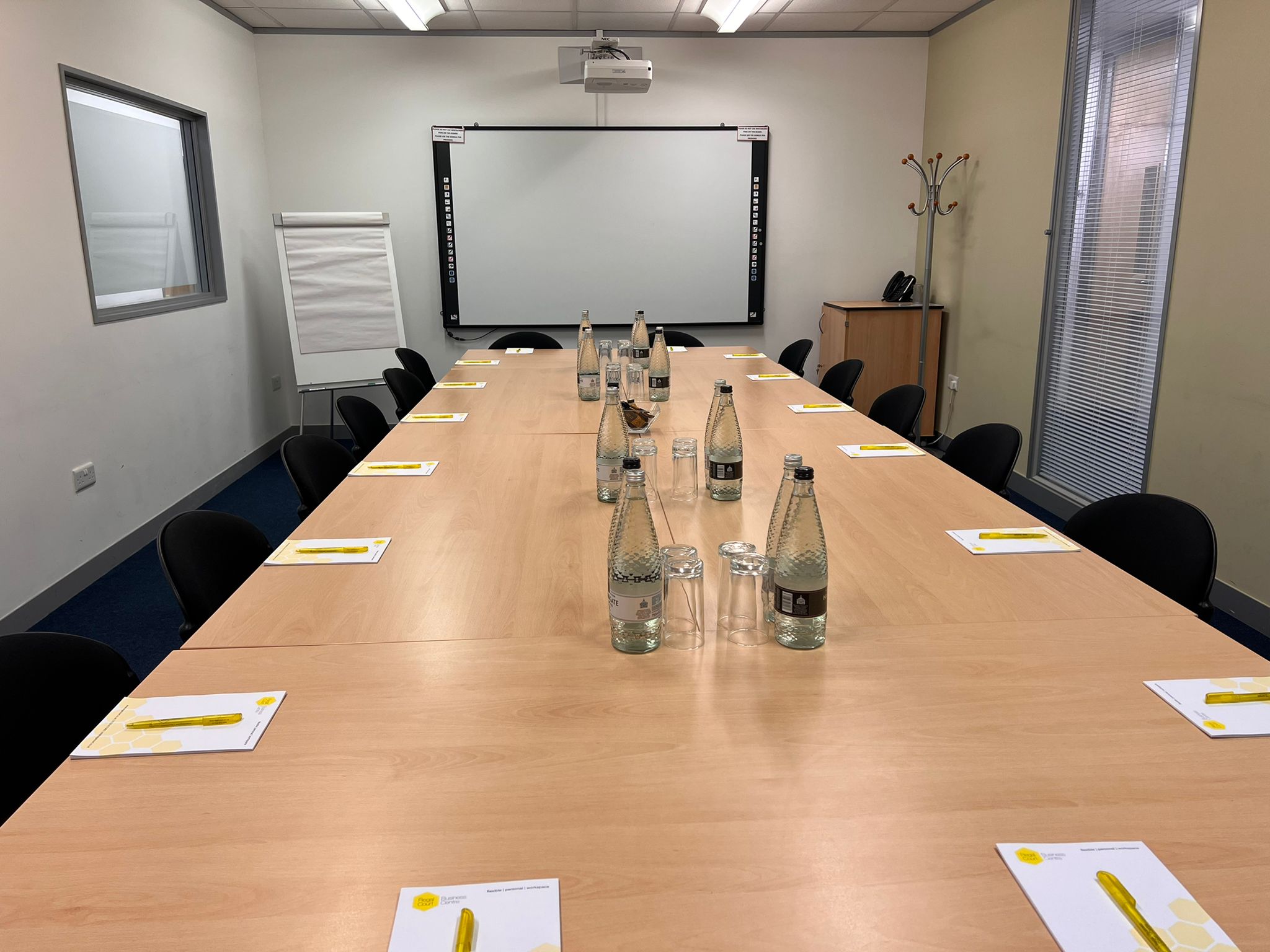 "Picasso meeting room with long wooden table, ideal for professional gatherings and brainstorming."