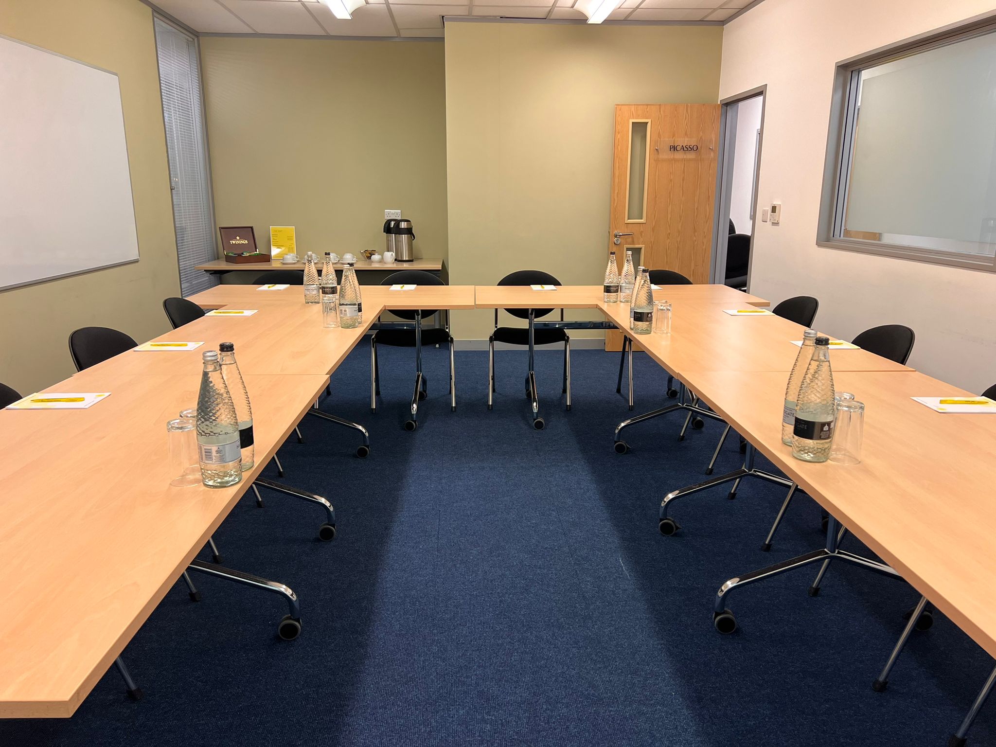 Meeting room setup with rectangular table, notepads for collaborative session.
