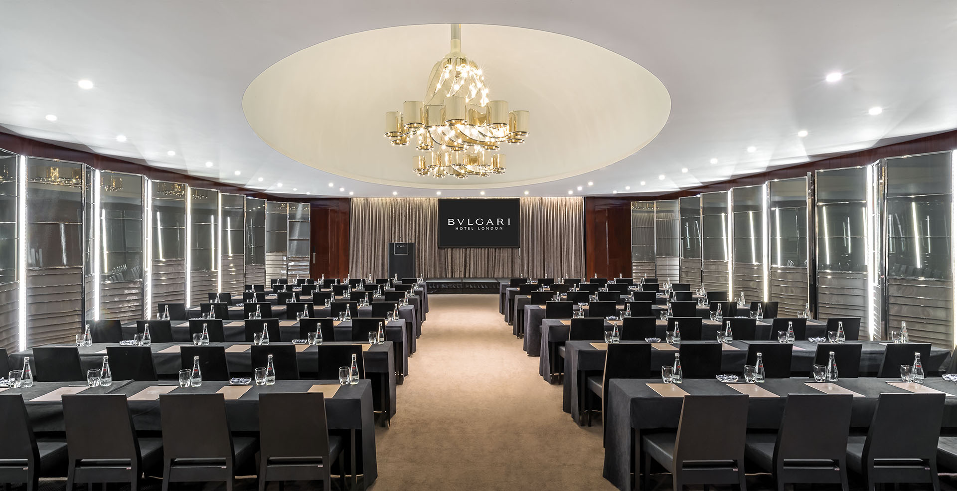 Ballroom at Bulgari Hotel London, featuring sleek tables for corporate events and luxury chandelier.