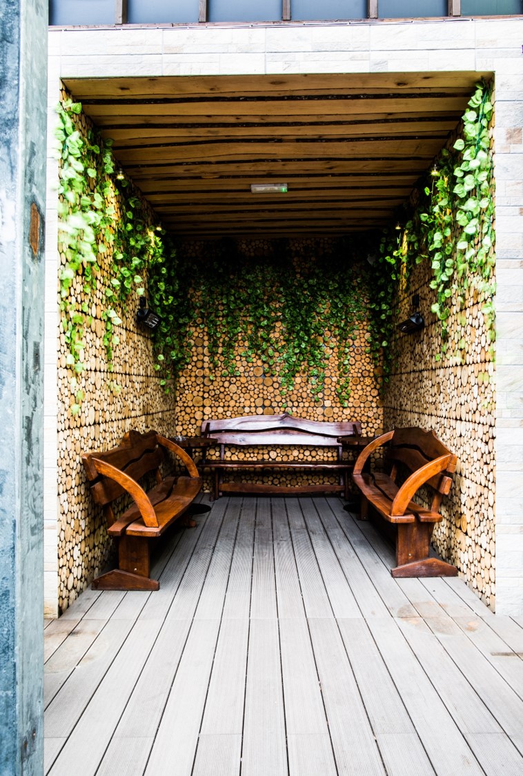 Cozy nature-inspired meeting space with wooden benches for informal discussions in London.