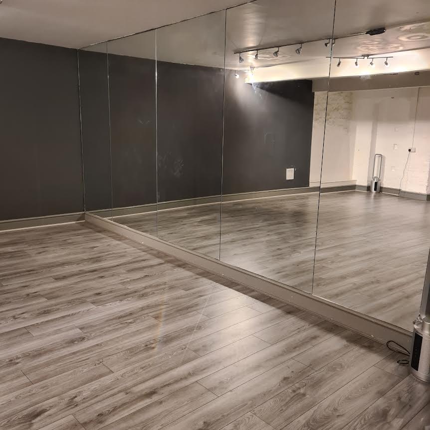 Versatile recording studio with mirrored walls, perfect for workshops and fitness classes.