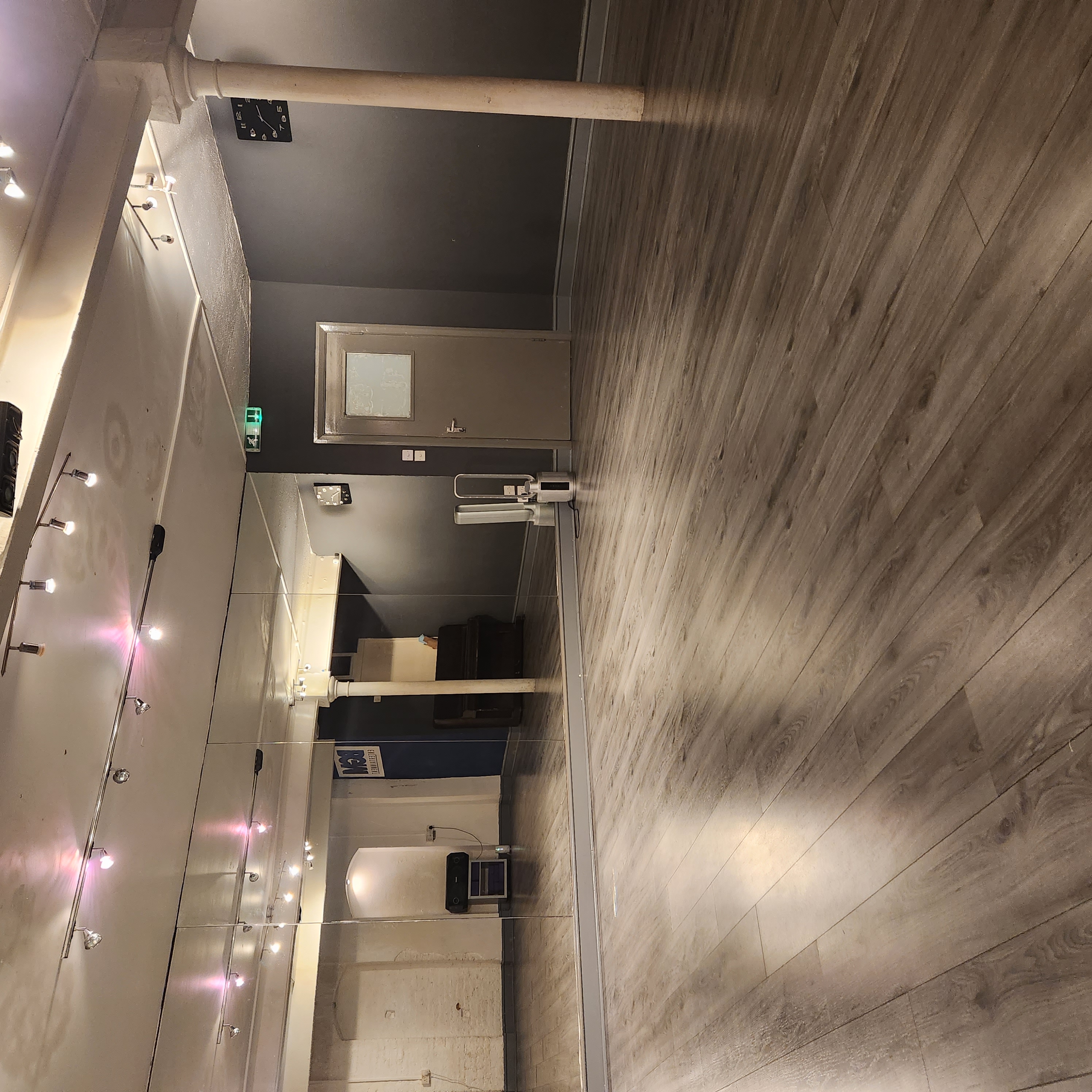 Versatile recording studio with polished wooden floor, ideal for workshops and fitness classes.